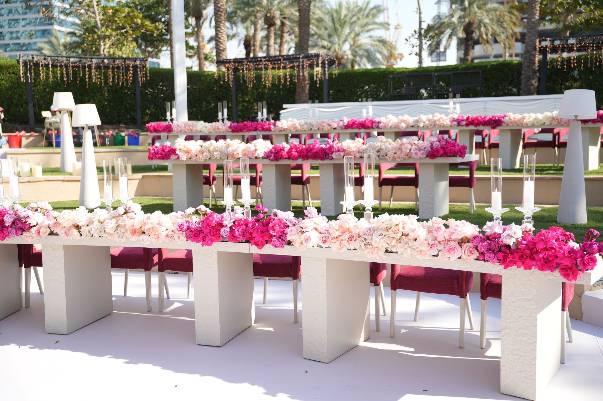 Curved white banquet tables runnered with ombré roses from ivory to fuchsia at One&Only Royal Mirage Dubai