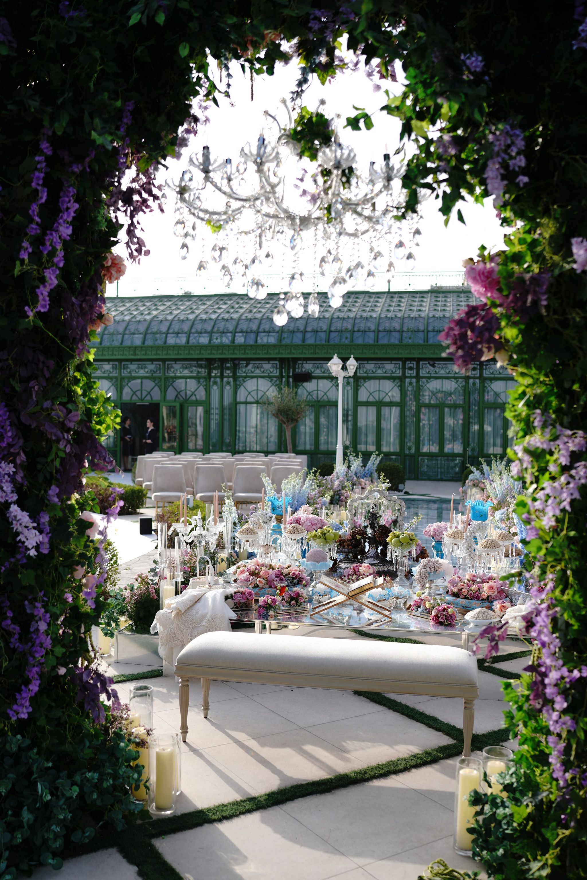 Persian sofreh table seen through a wisteria arch, conservatory behind, at Four Seasons Resort Dubai at Jumeirah Beach
