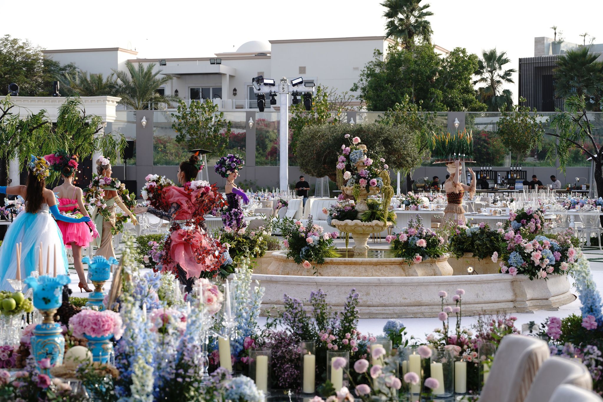 Performers in floral costumes beside a flower-dressed fountain at Four Seasons Resort Dubai at Jumeirah Beach
