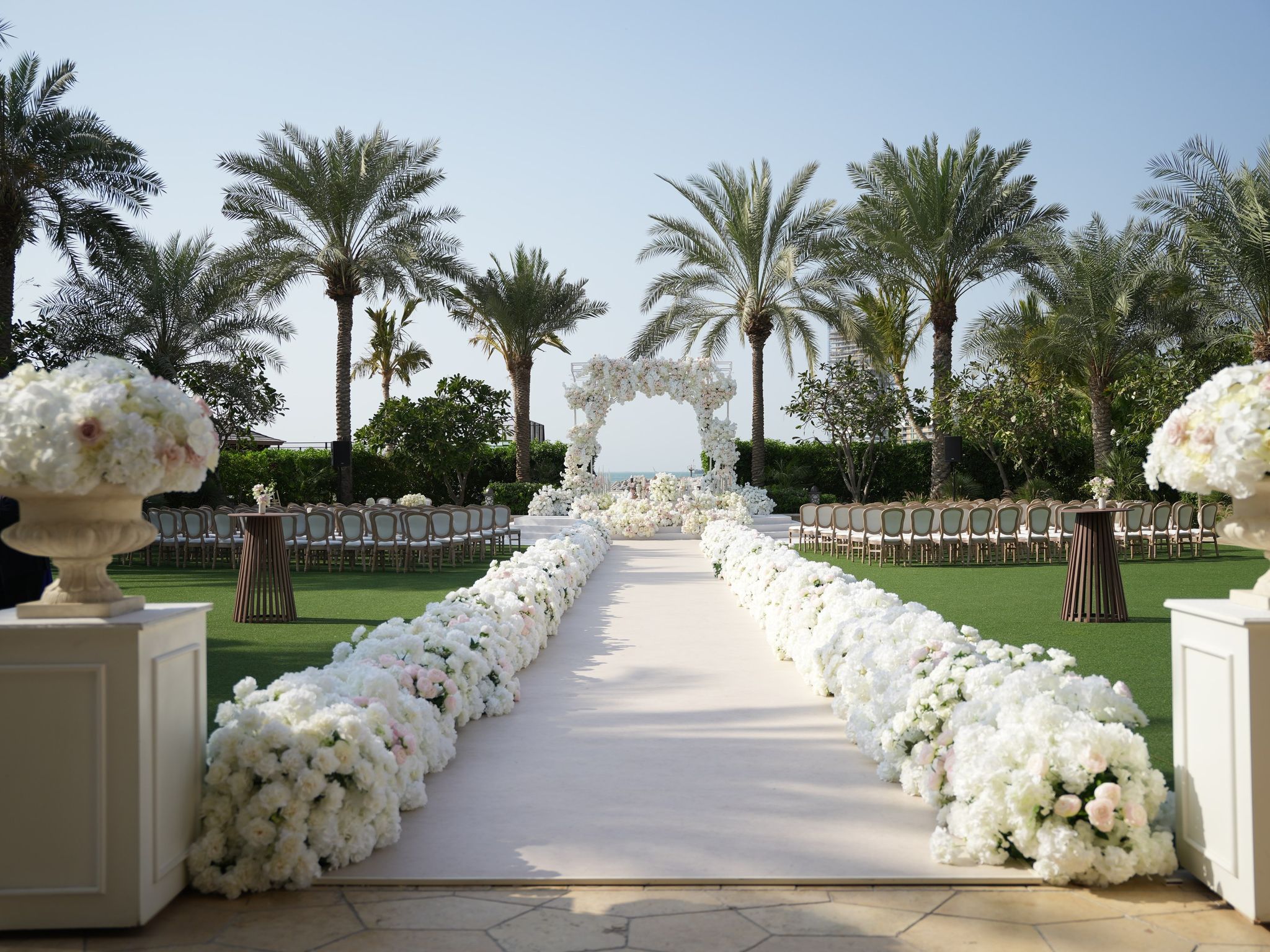 Hydrangea-lined aisle leading to a floral arch at Four Seasons Resort Dubai at Jumeirah Beach