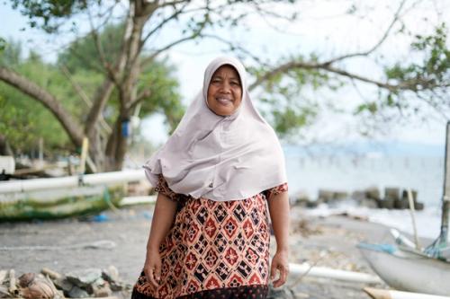 Indonesia: Meimei is a fishmonger whose community experiences damaging flash floods. Oxfam and local partner, KONSEPSI, are supporting the community in anticipatory action training and by installing measurement markers. Aimee Han/Oxfam. Oxfam acknowledges the support of the Australian Government through the Australian NGO Cooperation Program (ANCP).