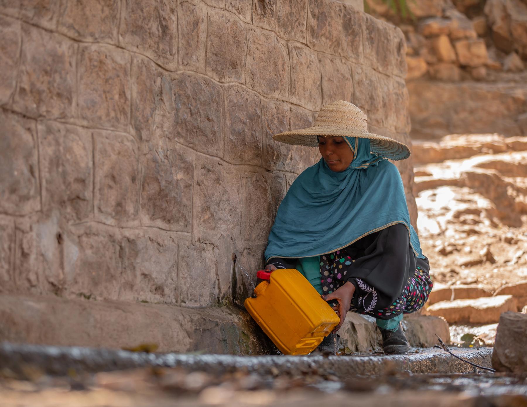 Yemen: Upon reaching the well, Rawya carefully fills her water container. The water is neither clean nor safe, but it is the only available source for her and her family. Photo:Ahmed Al-Basha / Oxfam Intermón