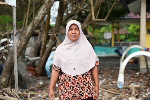 Indonesia: Meimei is a fishmonger whose community experiences damaging flash floods. Oxfam and local partner, KONSEPSI, are supporting the community in anticipatory action training and by installing measurement markers. Aimee Han/Oxfam. Oxfam acknowledges the support of the Australian Government through the Australian NGO Cooperation Program (ANCP).