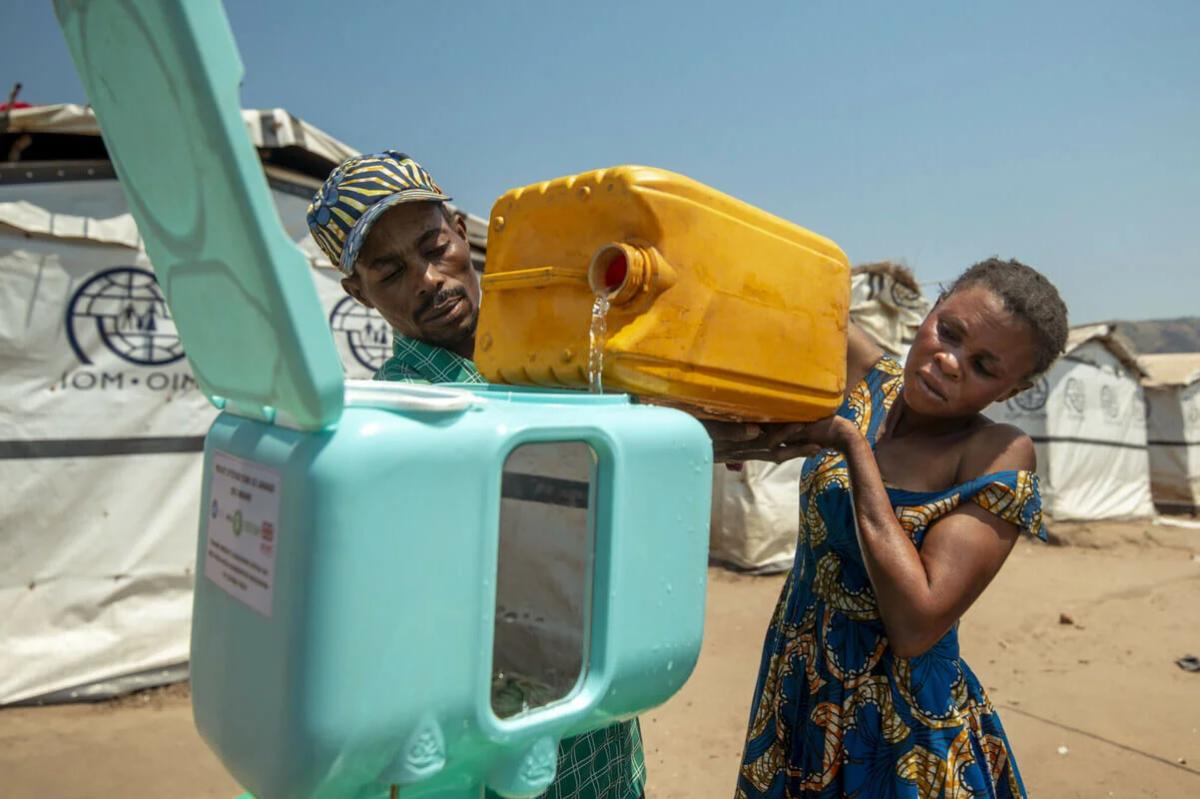 A woman fills a jerry can with clean water from an Oxfam tap stand
