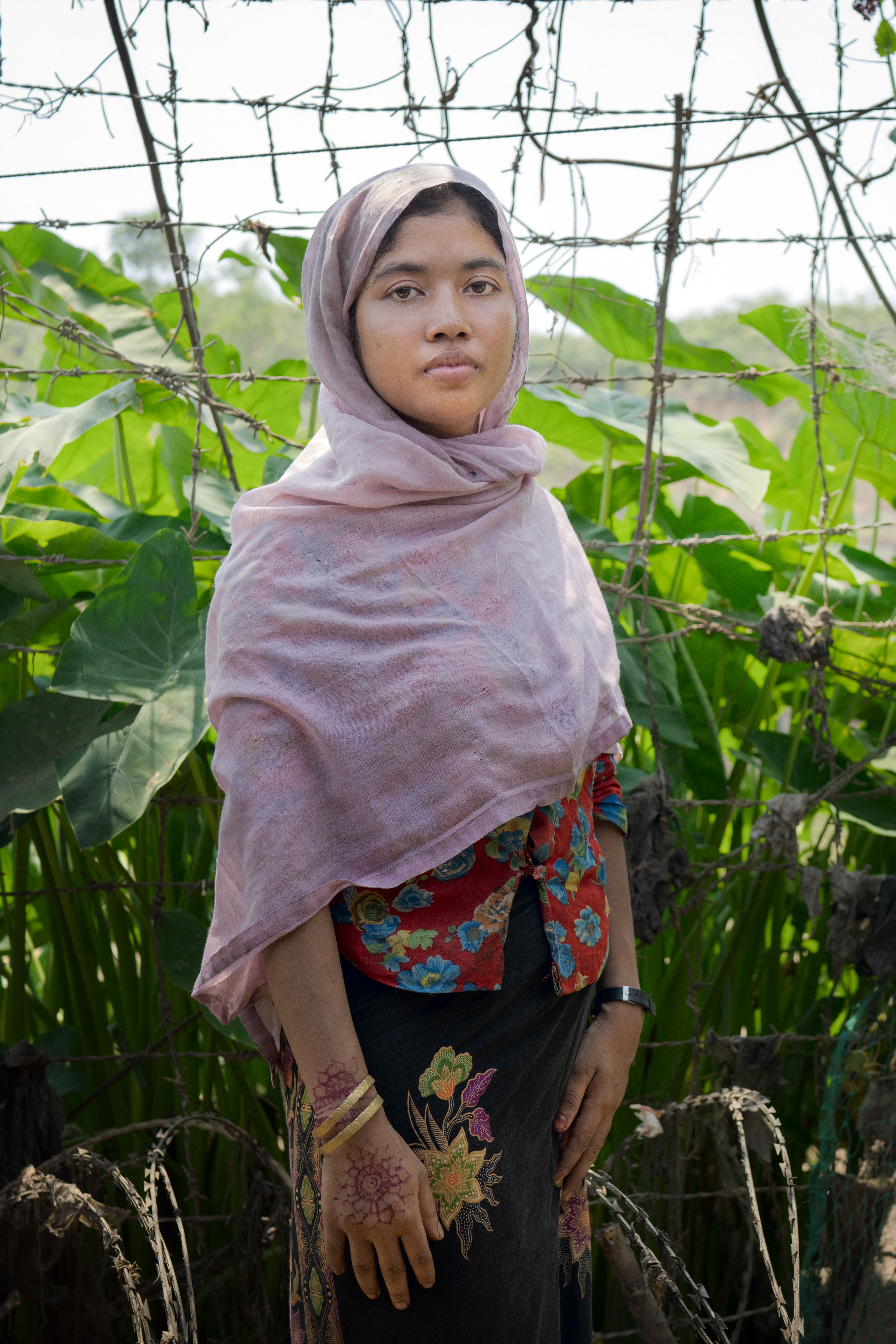 Shamsun stood in her yard where she grows vegetables