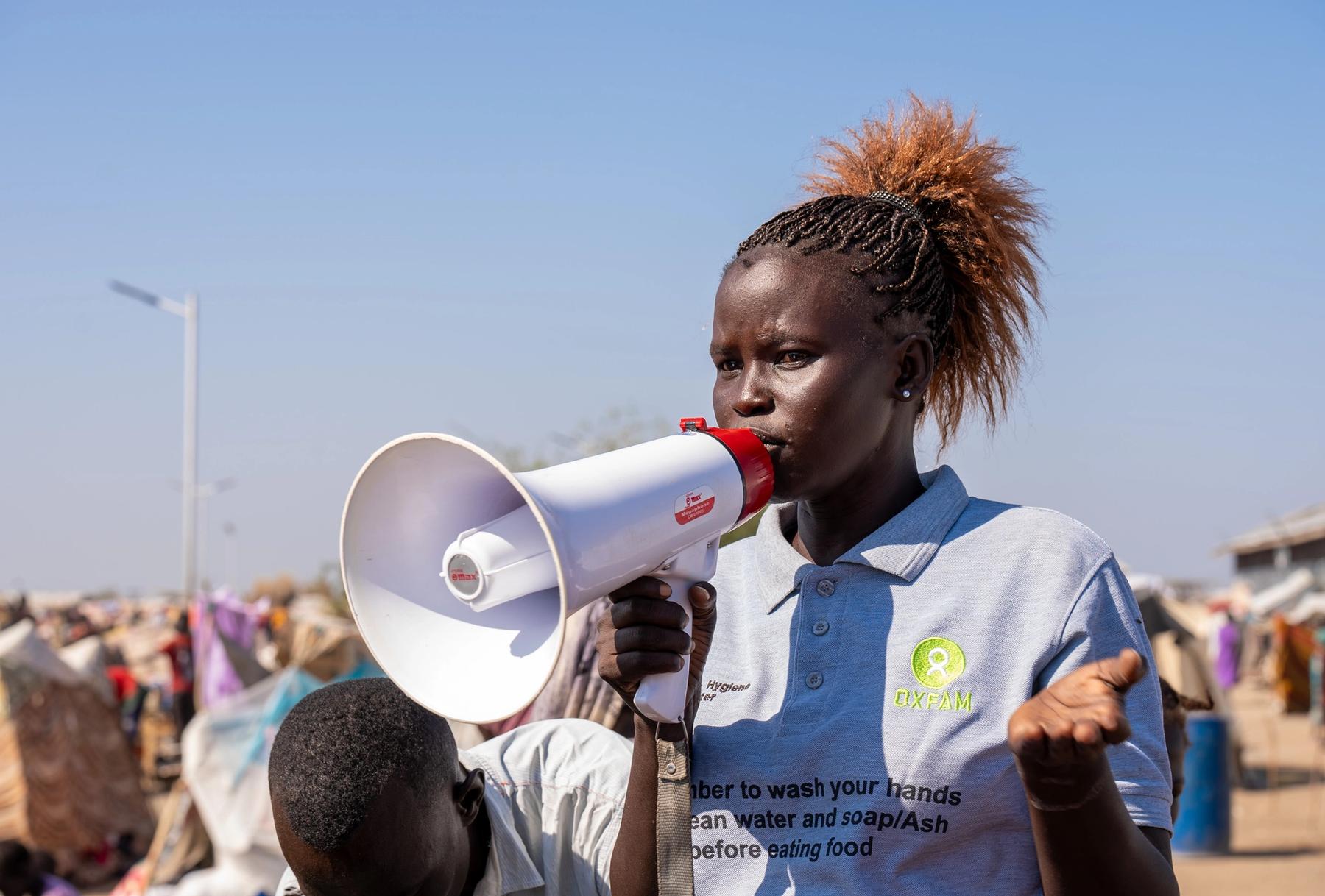 South Sudan: Jun Ajuk, Oxfam health promoter speaks to Sudan refugee and returnees on the importance of mantaining hygiene to avoid spread of dieases. Photo: Herison Philip Osfaldo/Oxfam