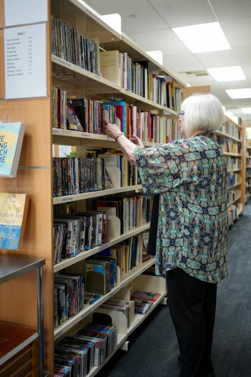 A volunteer stacking shelves in the bookshop