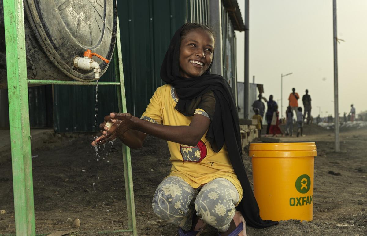 South Sudan, Renk: Refugee Asia* washing her hand at an Oxfam supported WASH facility at their shelter at the transit center in Renk. Photo: Peter Caton/Oxfam
