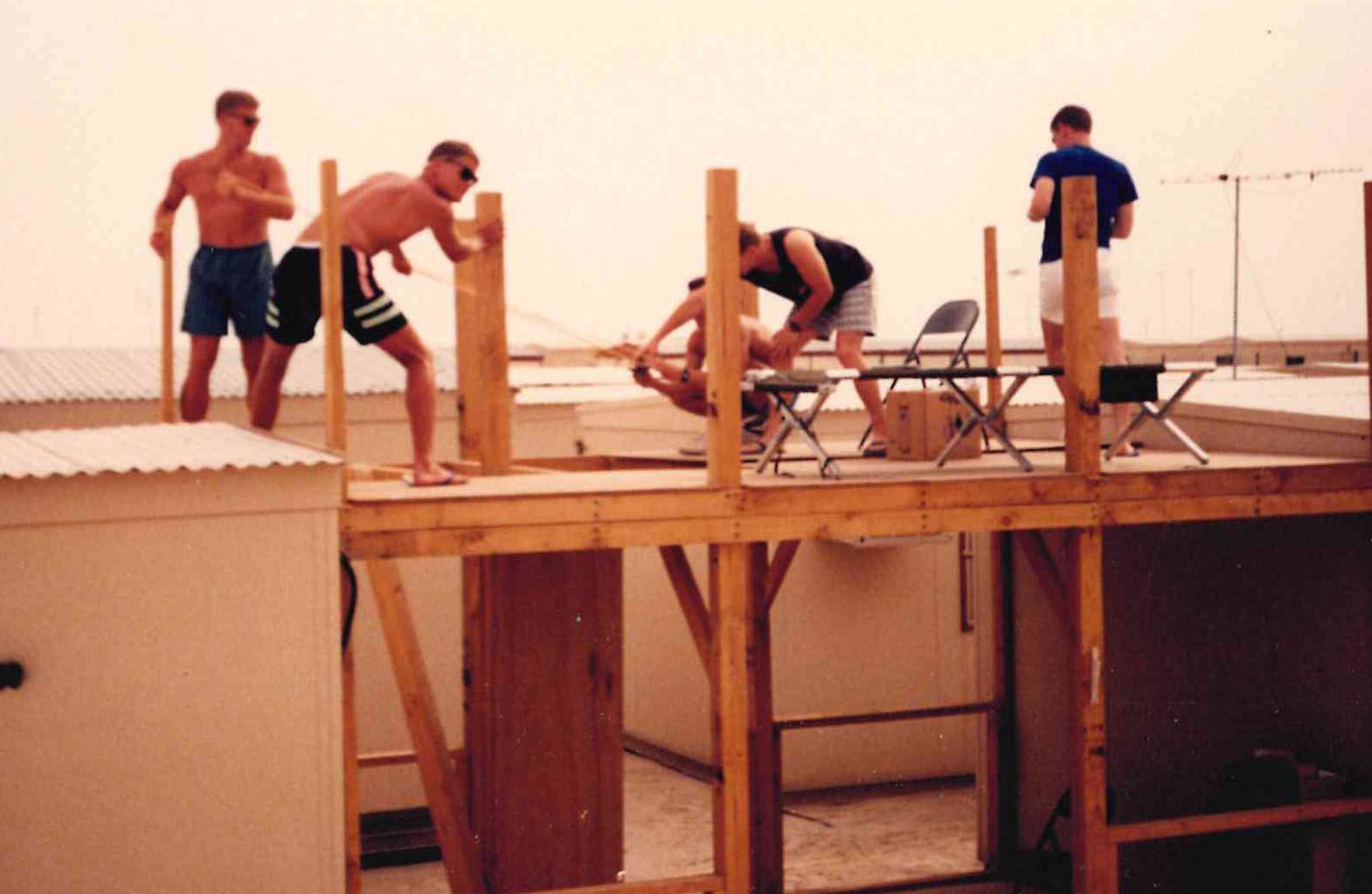 Scrap lumber, two-by-fours, and a desert sky — the squadron building its own quarters at Al Dhahfra. Shwabu Dhabi!