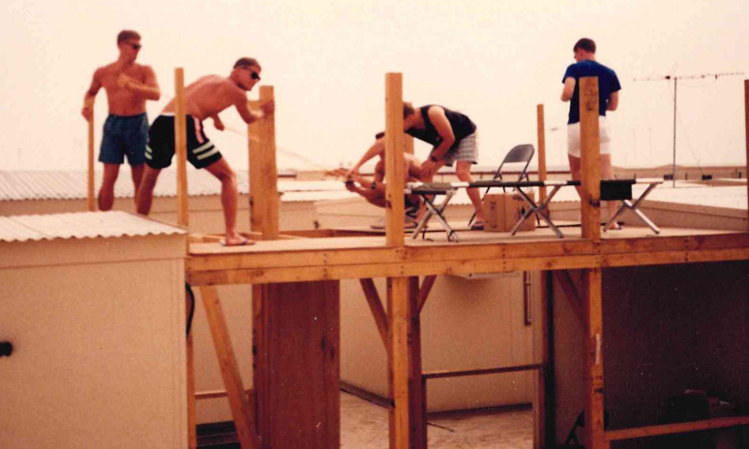 Scrap lumber, two-by-fours, and a desert sky — the squadron building its own quarters at Al Dhahfra. Shwabu Dhabi!