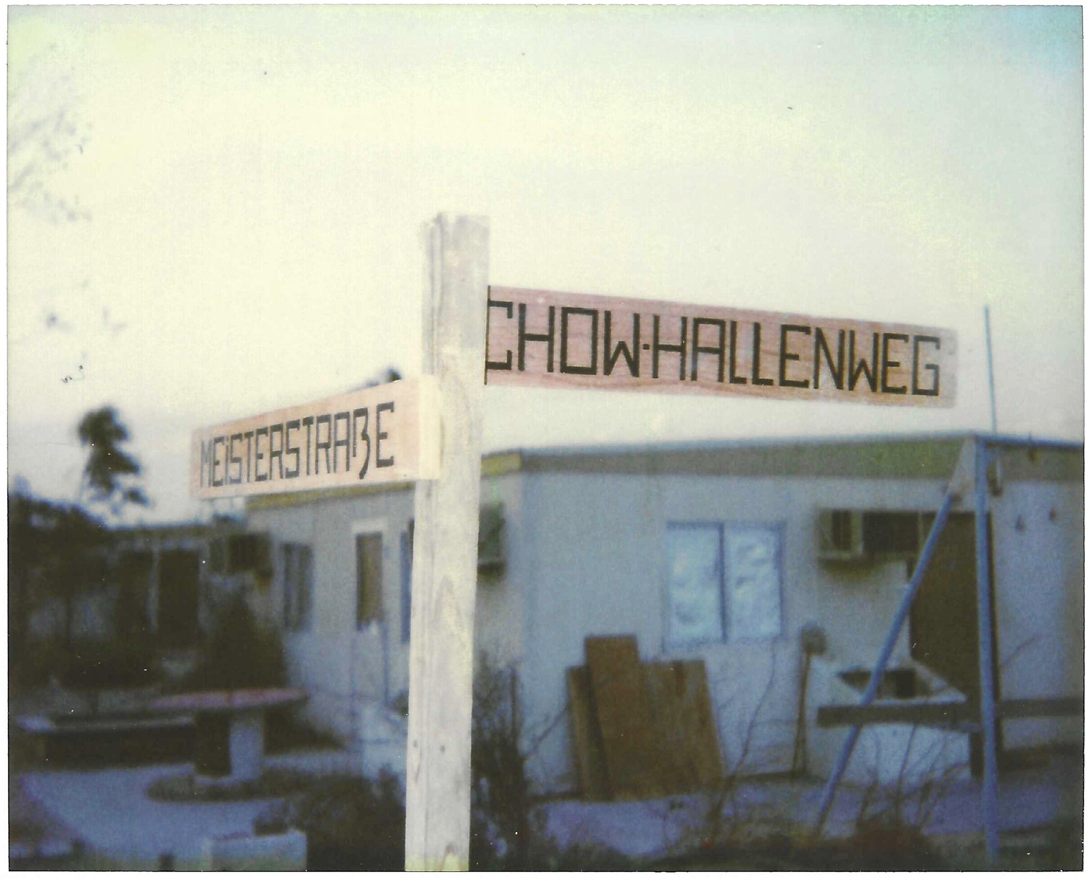 Hand-painted street signs — German precision applied to a Tent City.