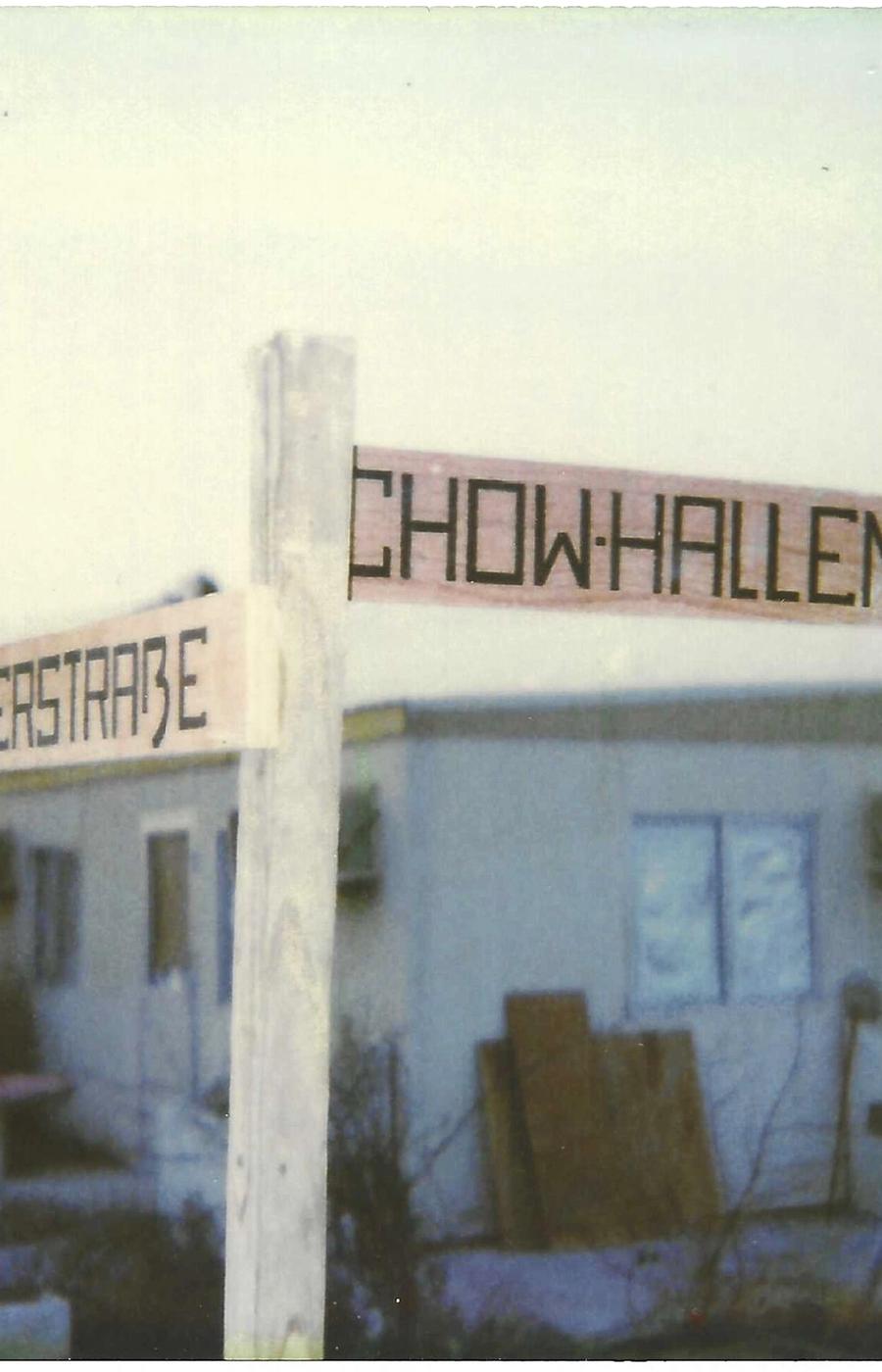 Hand-painted street signs — German precision applied to a Tent City.