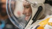 Side profile of woman in a space helmet, smiling.