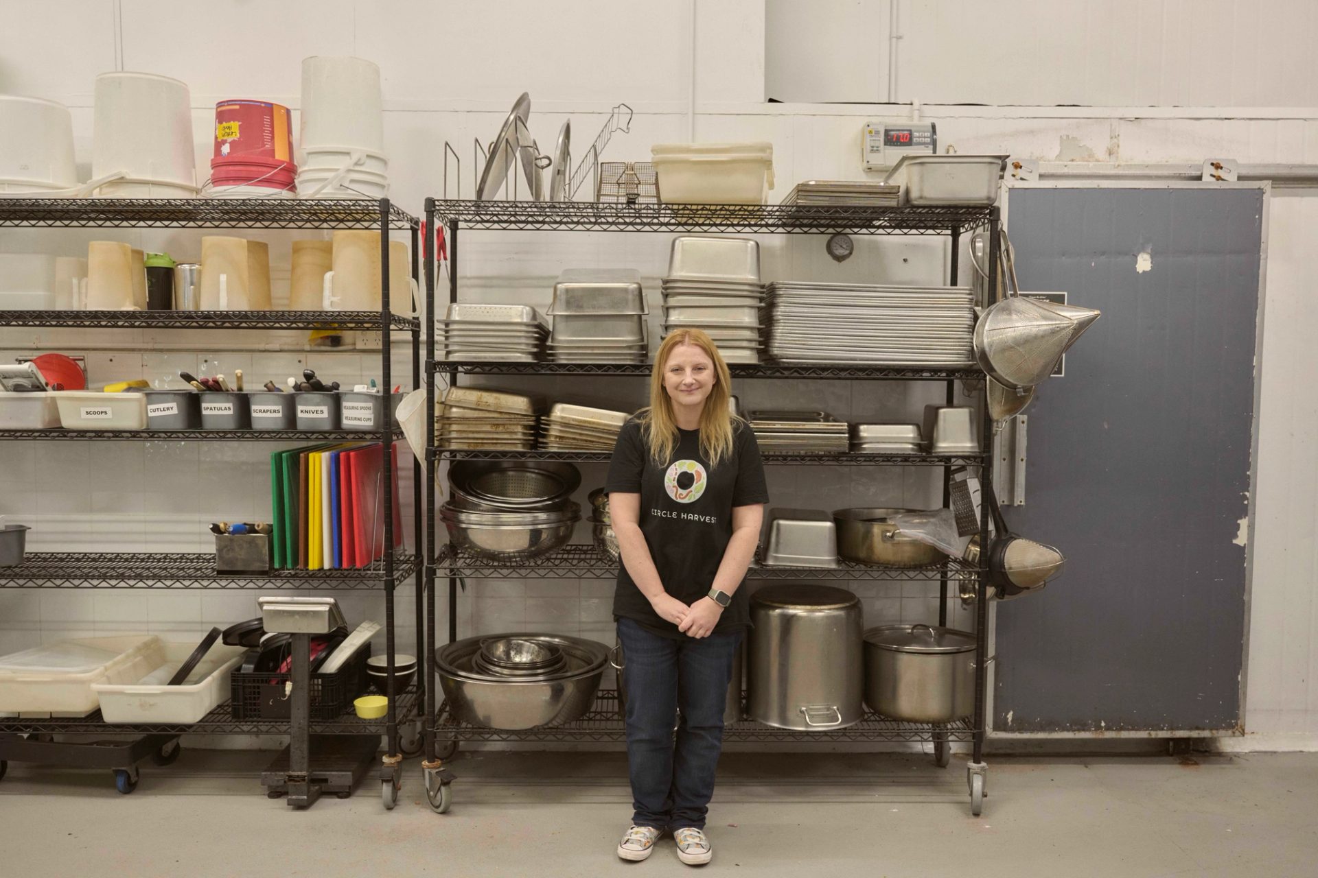Figure standing in front of kitchen supplies on shelving.