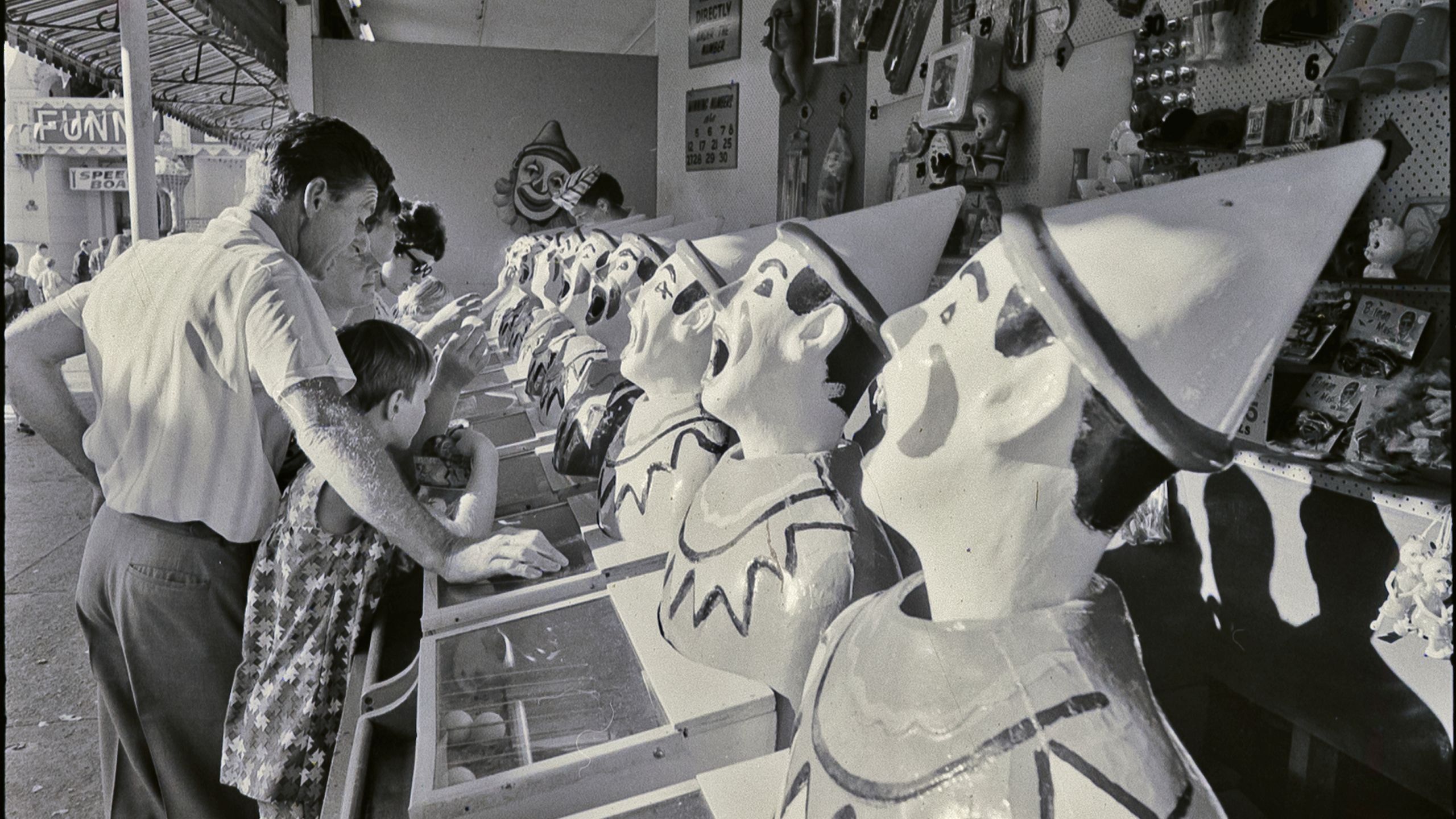 Photograph from negative with the caption "Coney Island spells fun to the child in any grown-up. Beneath the Harbour Bridge Sydney has its own version of Coney Island inside the bizarre mouth of Luna Park right on the waterfront."