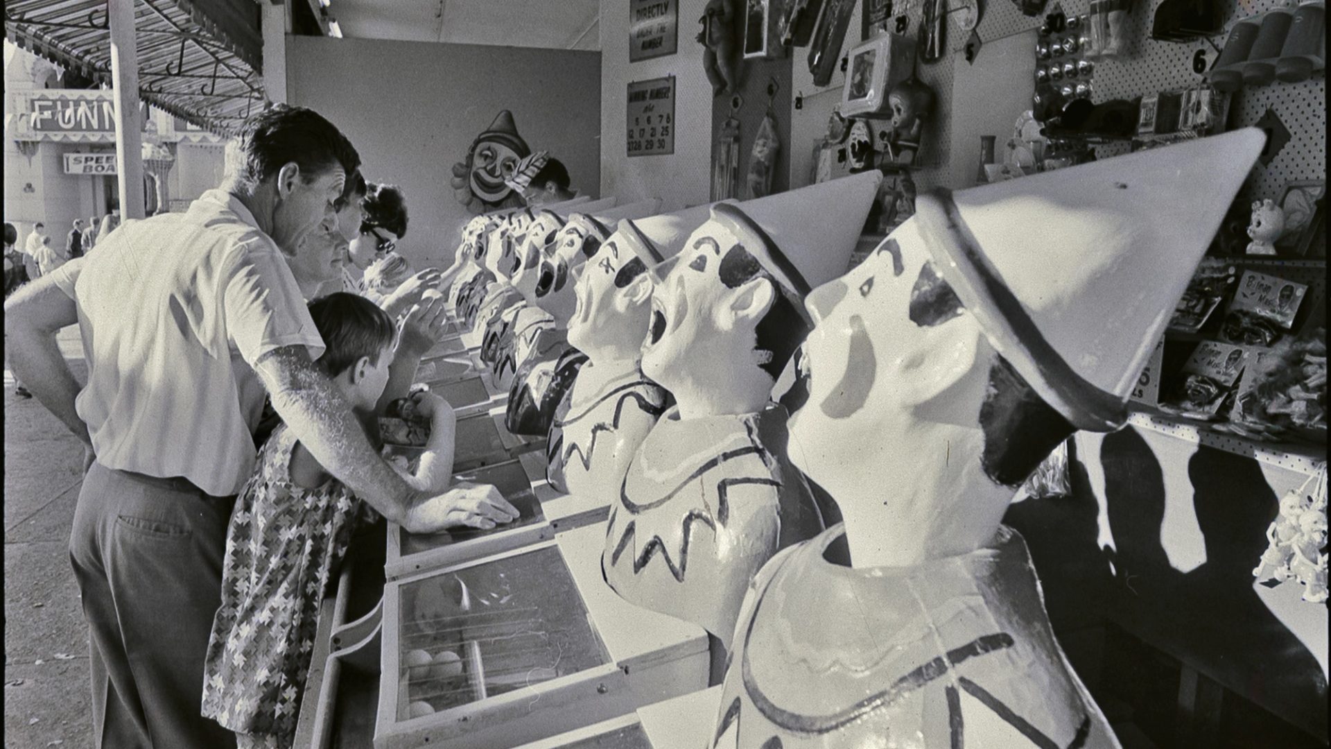 Photograph from negative with the caption "Coney Island spells fun to the child in any grown-up. Beneath the Harbour Bridge Sydney has its own version of Coney Island inside the bizarre mouth of Luna Park right on the waterfront."