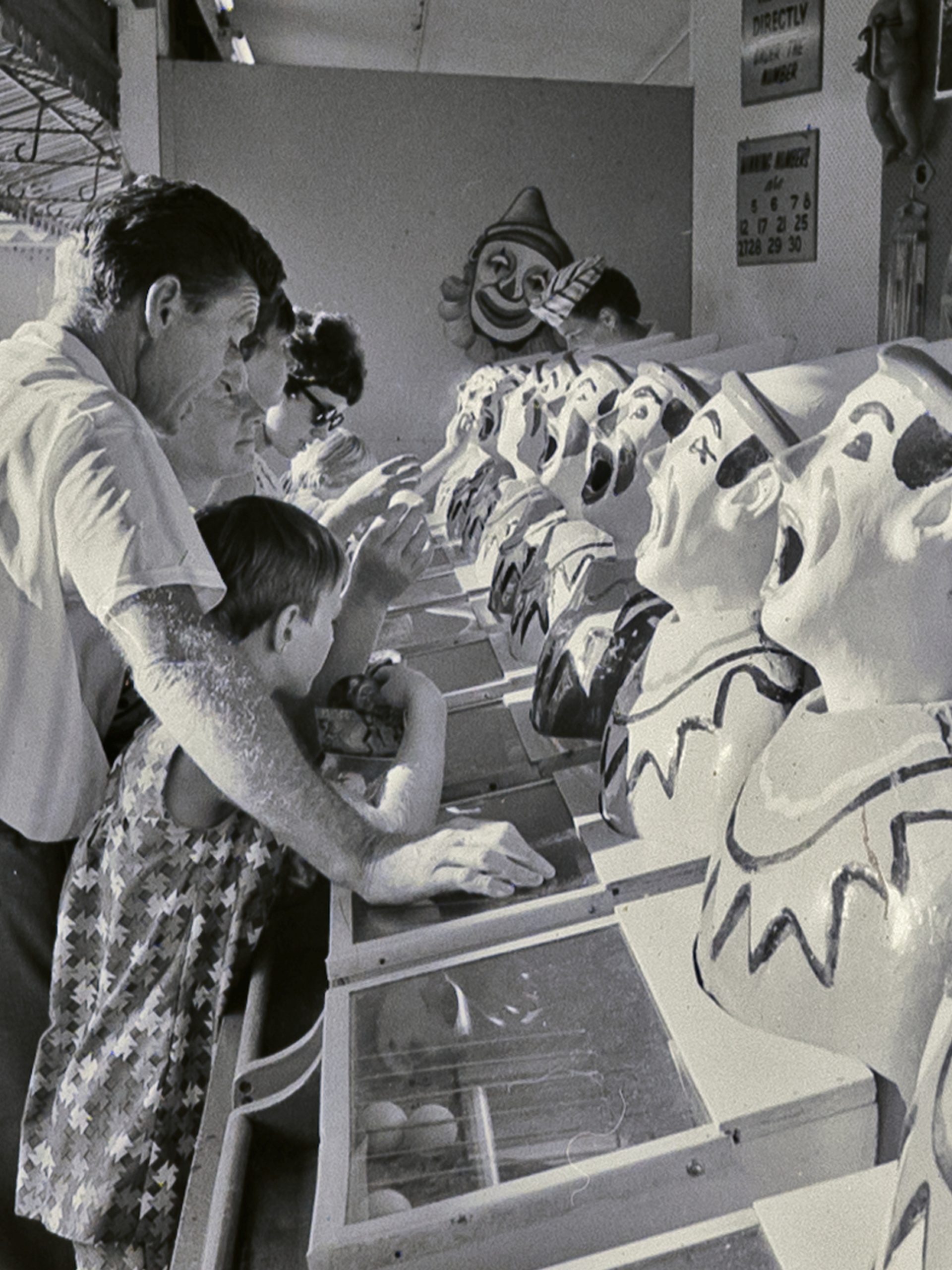 Photograph from negative with the caption "Coney Island spells fun to the child in any grown-up. Beneath the Harbour Bridge Sydney has its own version of Coney Island inside the bizarre mouth of Luna Park right on the waterfront."