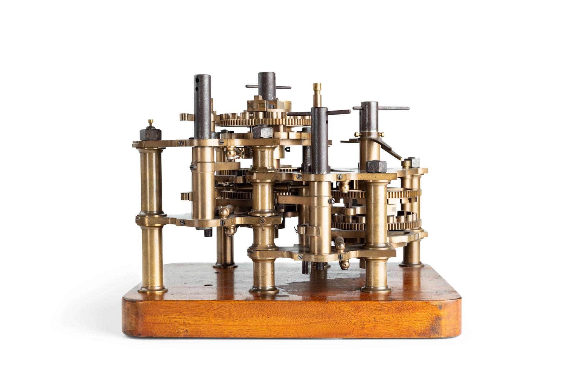 An engine with six ferrous metal shafts supporting various bronz wheels with engraved numbers