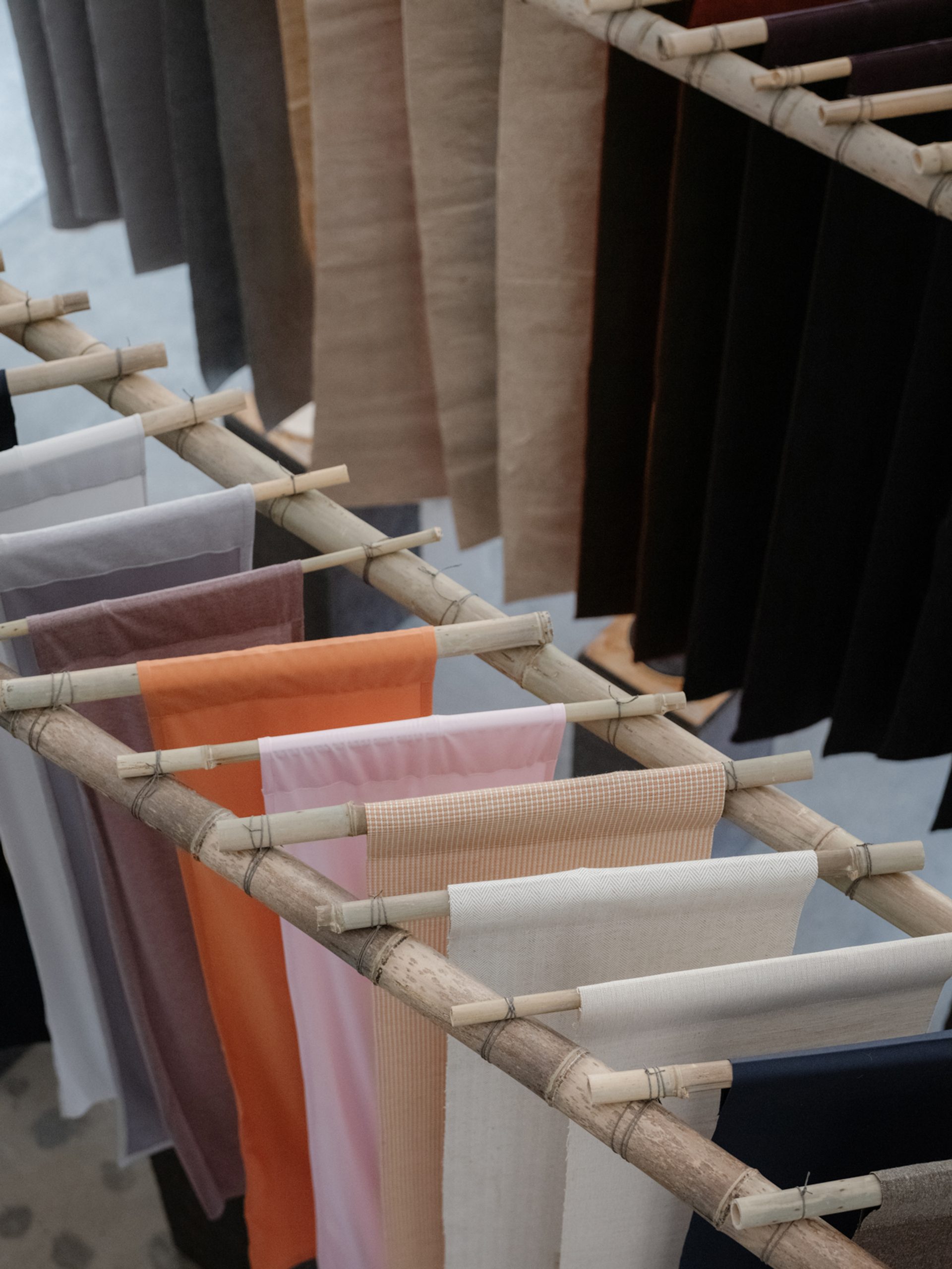 Colourful pieces of fabric hanging from babmboo