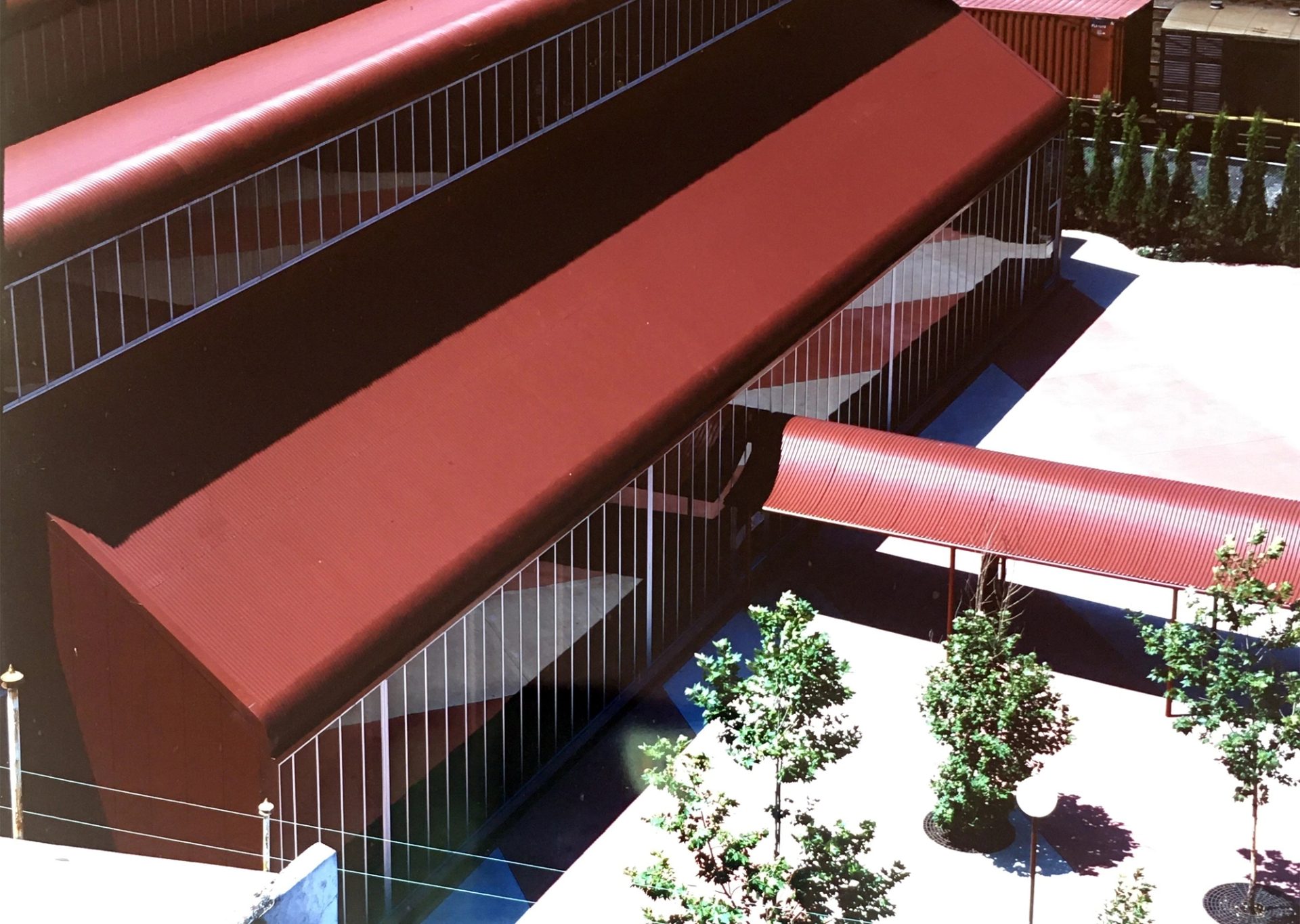 Colour photograph of red corrugated iron building from a high vantage point