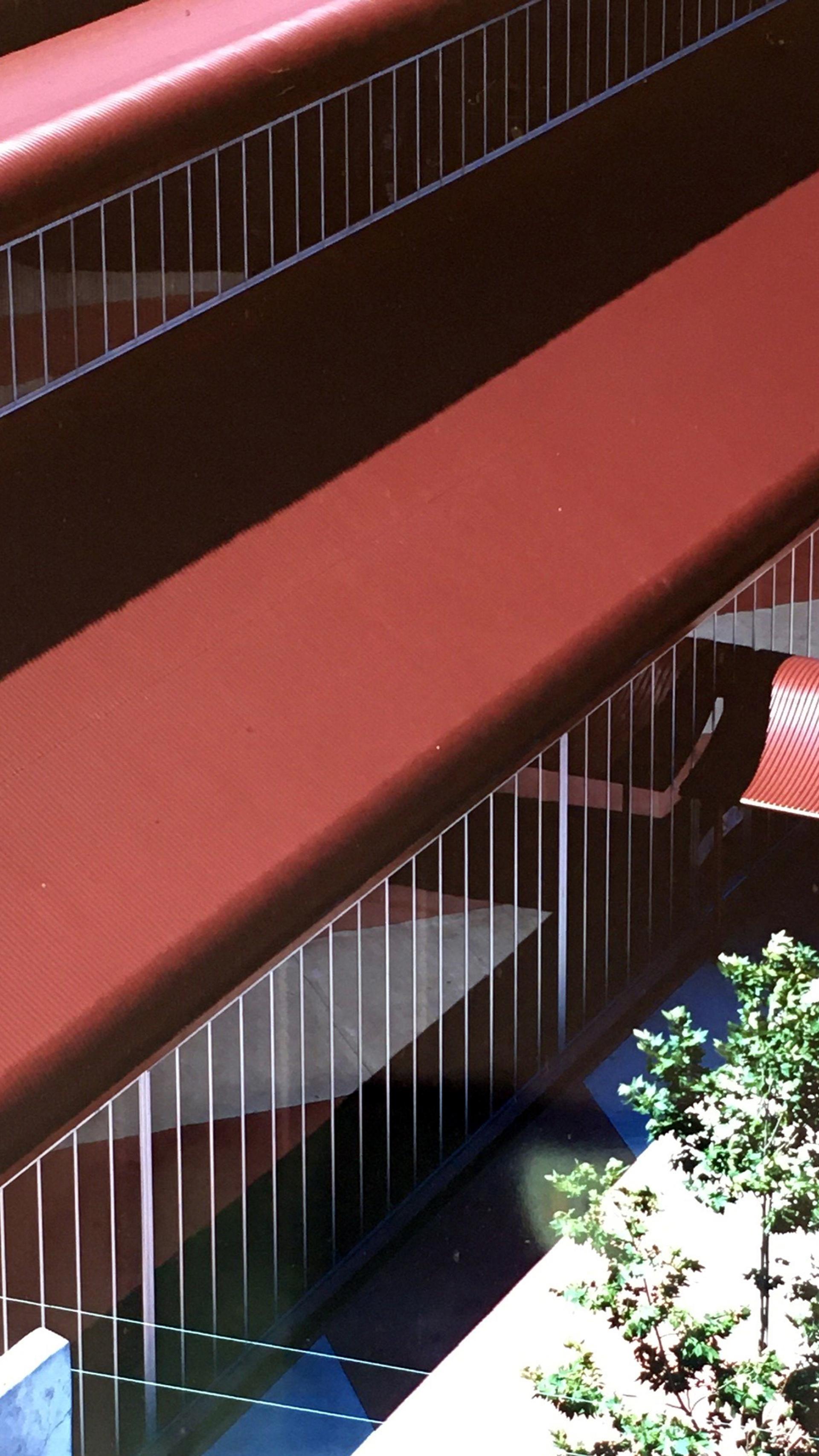 Colour photograph of red corrugated iron building from a high vantage point