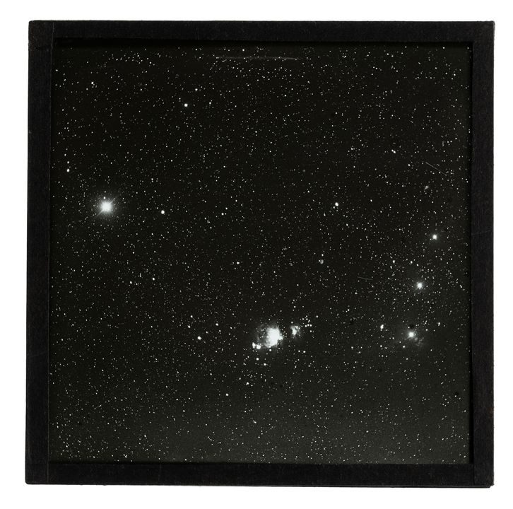 Glass plate slide with positive photographic image of a patch of stars in the sky.