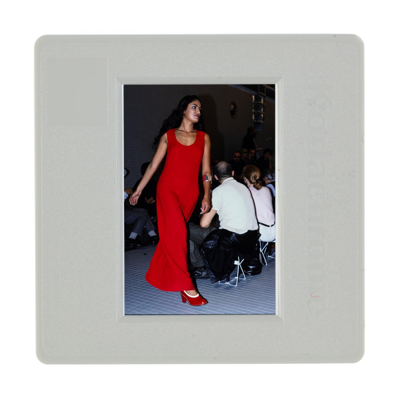 Runway model, wearing a red maxi-dress.