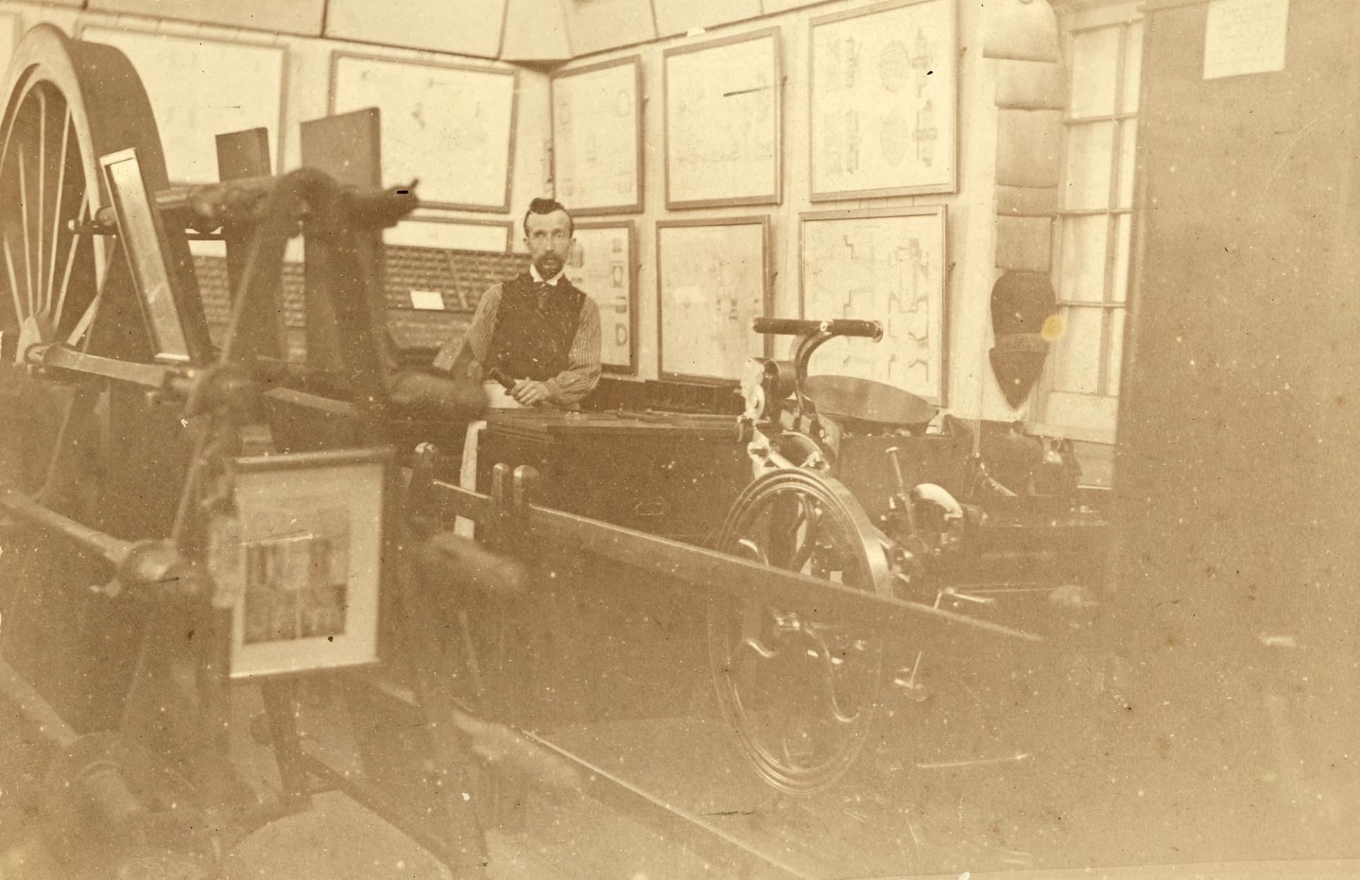 Sepia photograph of a man demonstrating machinery in public