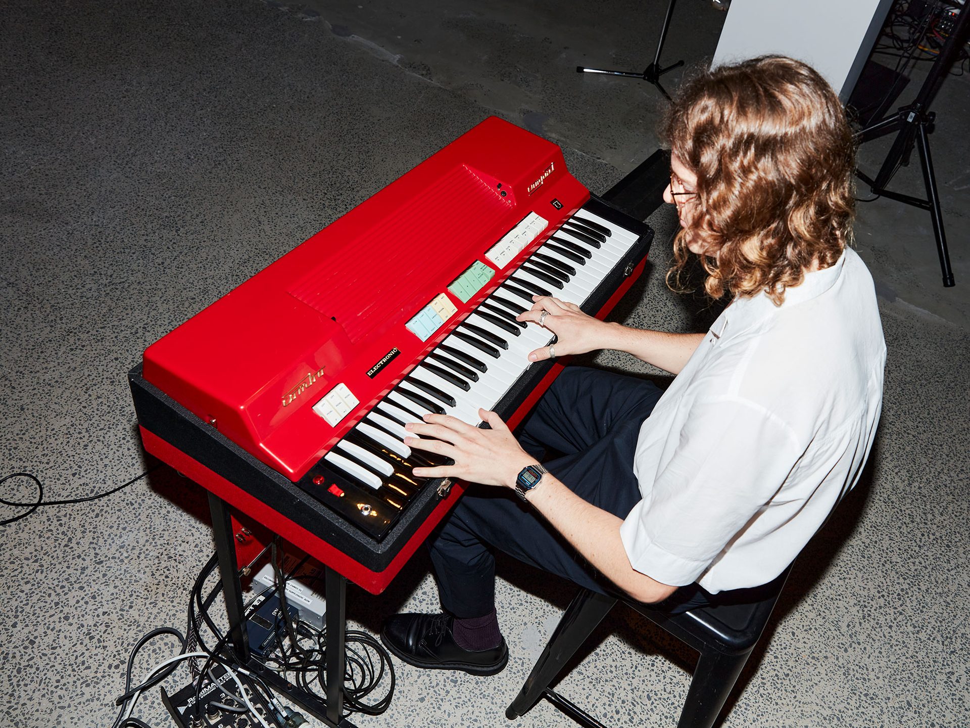 A person sits at a bright red keyboard.