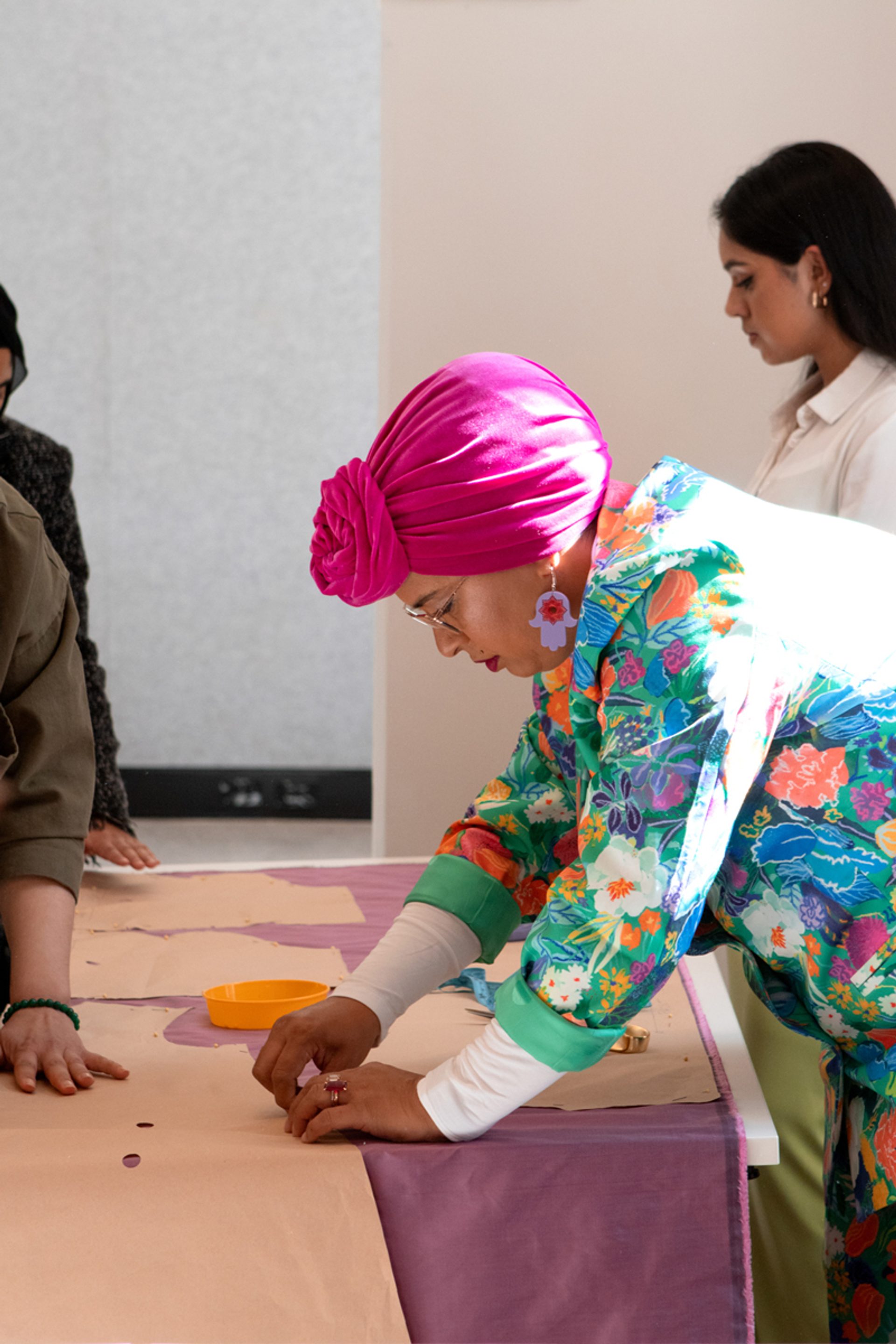 Figure leaning over pinning pattern to fabric