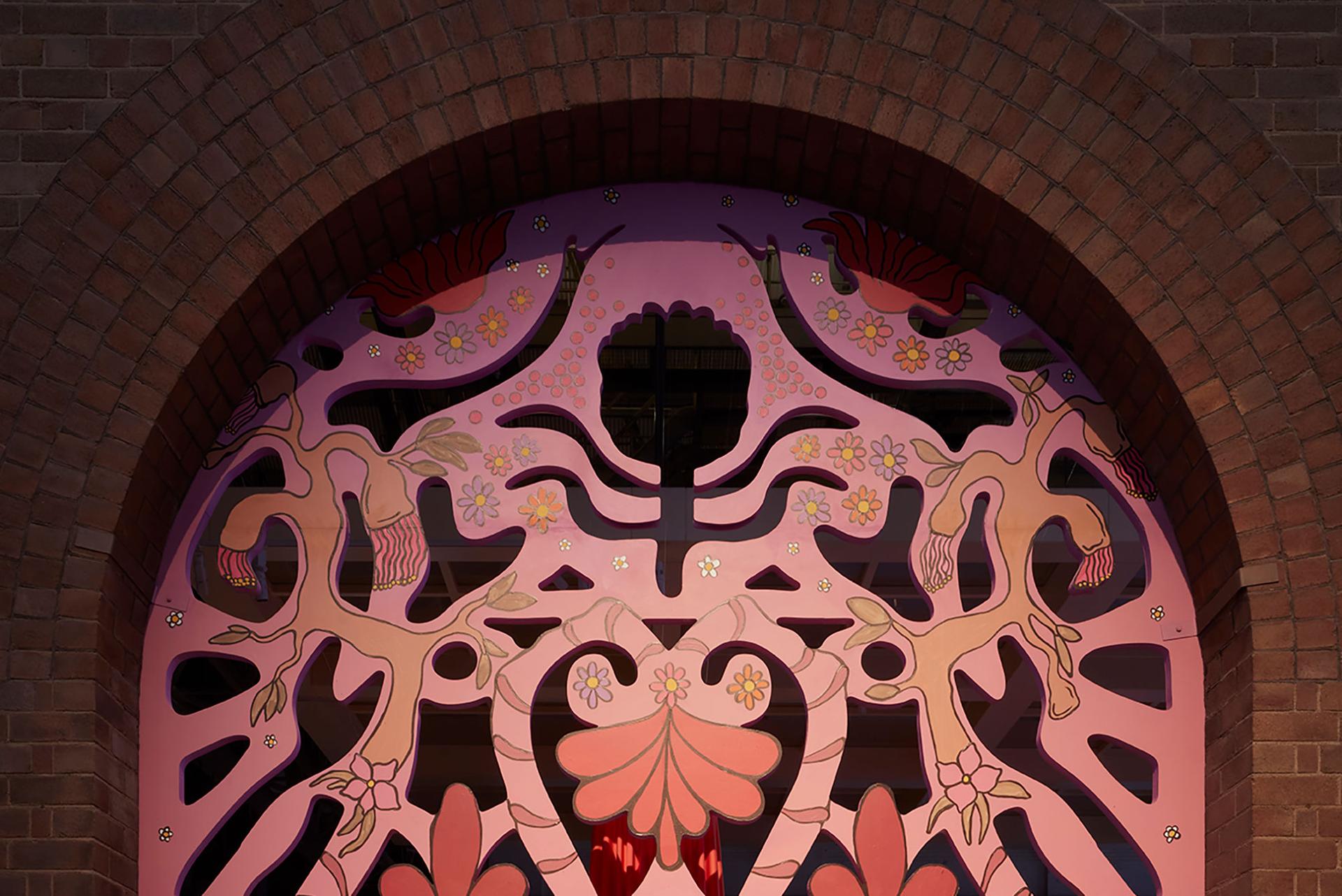 A large carved archway in gold, pink and reds.