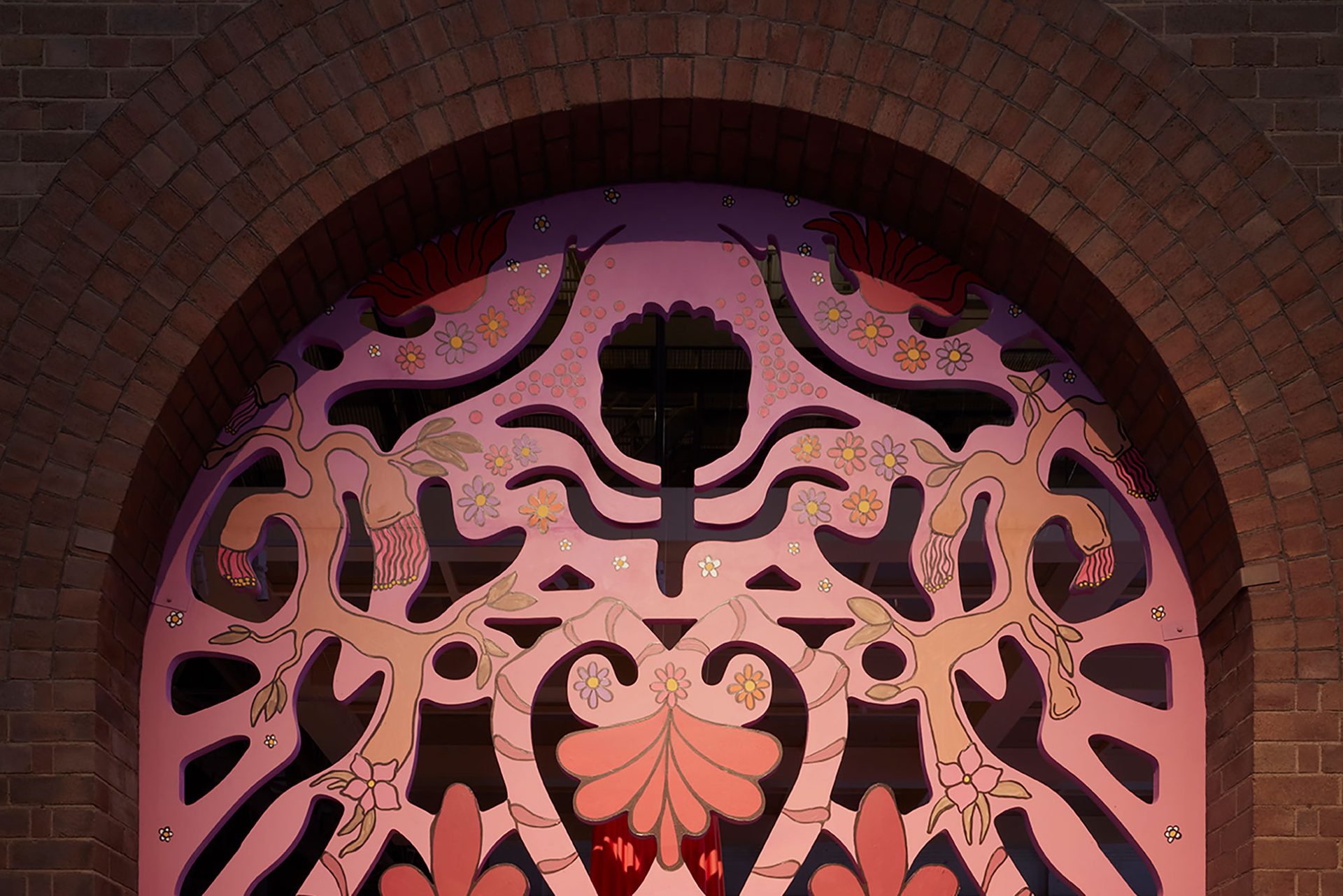 A large carved archway in gold, pink and reds.