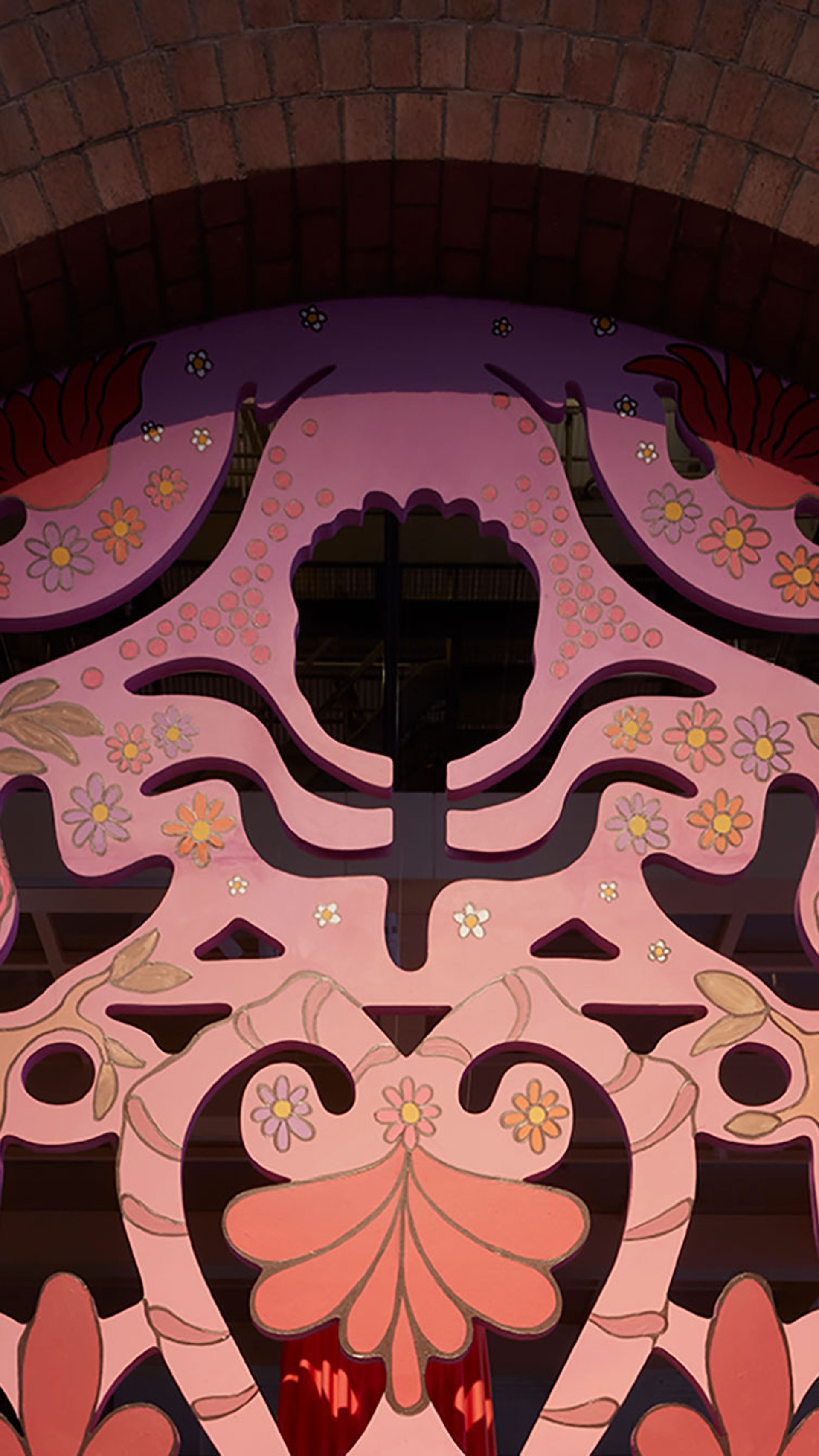 A large carved archway in gold, pink and reds.