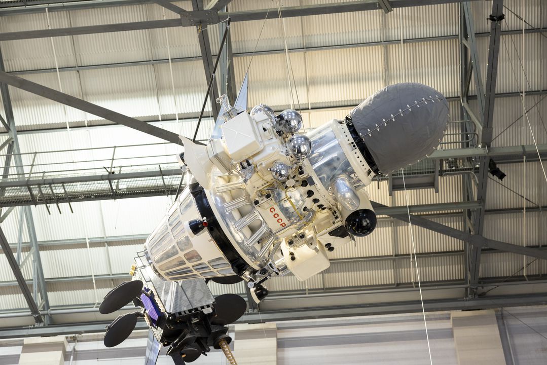 Small white and silver spacecraft suspended from ceiling.