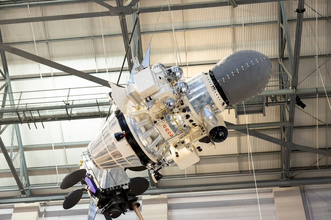 Small white and silver spacecraft suspended from ceiling.
