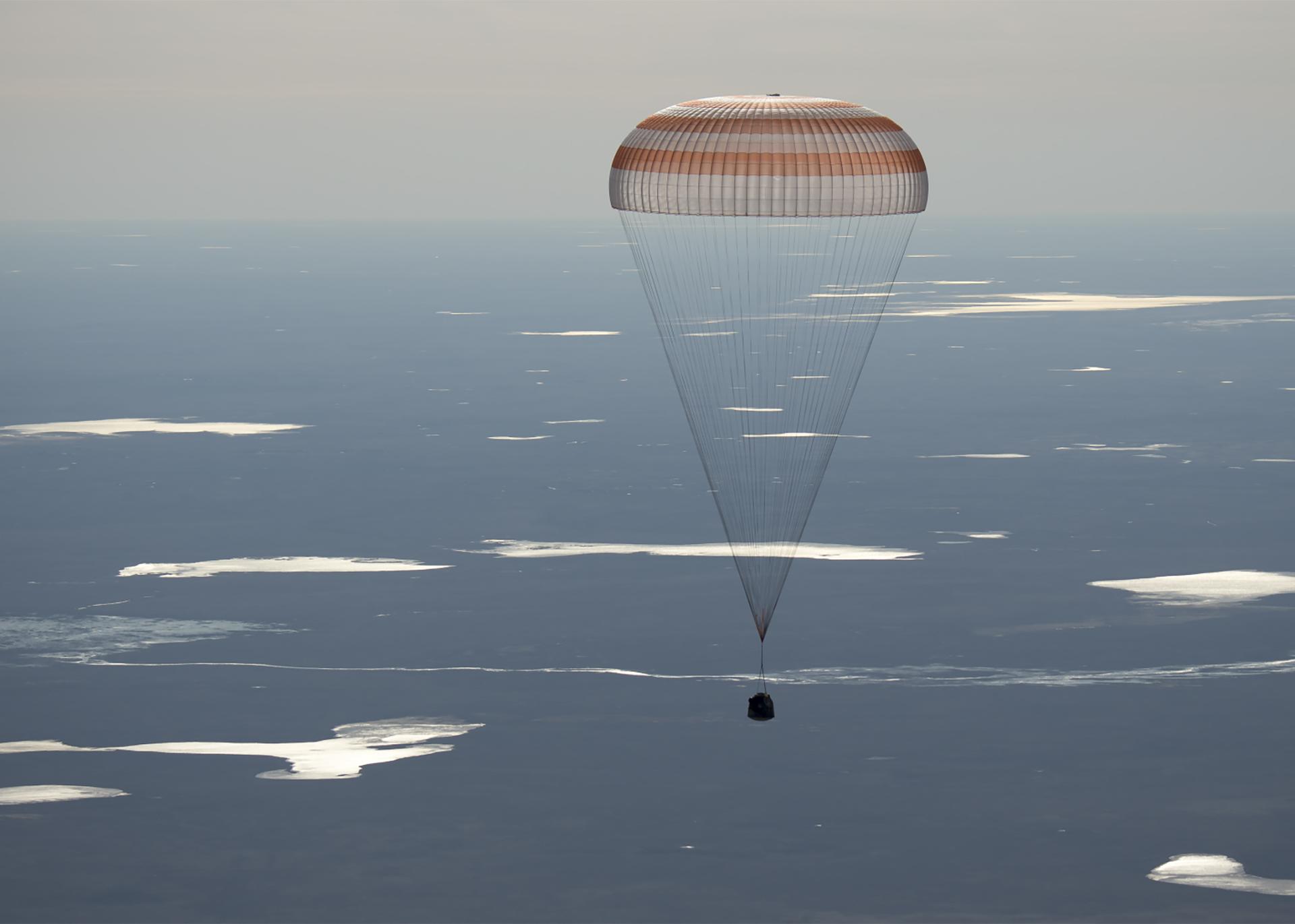 Image of the 50 Soyuz MS-02 landing, held by a parachute above the sky's atmosphere.