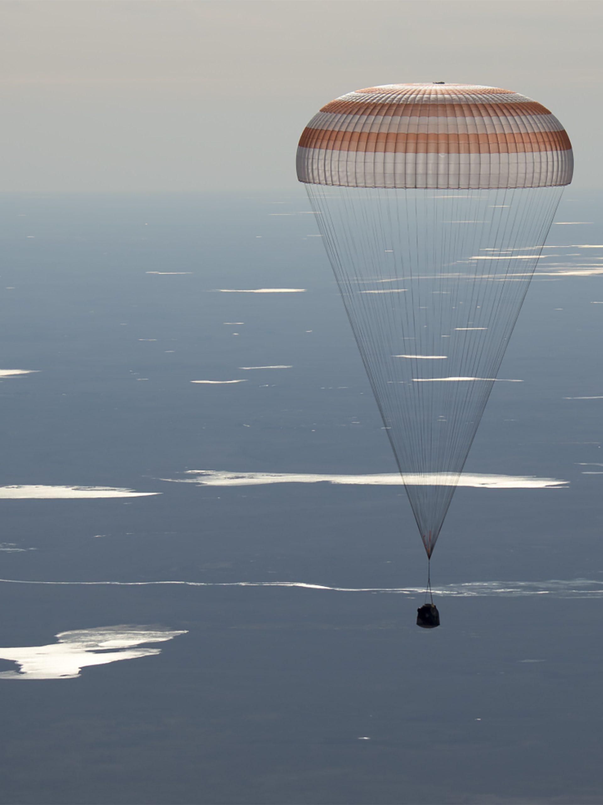 Image of the 50 Soyuz MS-02 landing, held by a parachute above the sky's atmosphere.