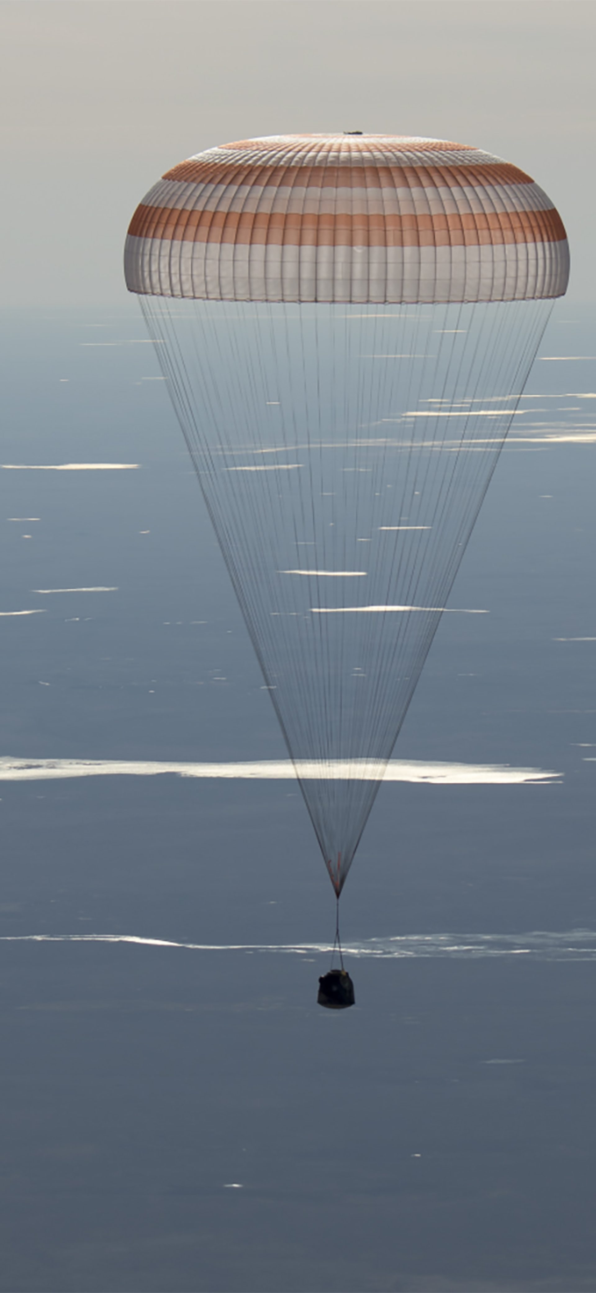 Image of the 50 Soyuz MS-02 landing, held by a parachute above the sky's atmosphere.