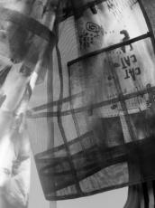 Close-up detail of a transparent mesh skirt layered over a patterned dress with red and orange floral sleeve
