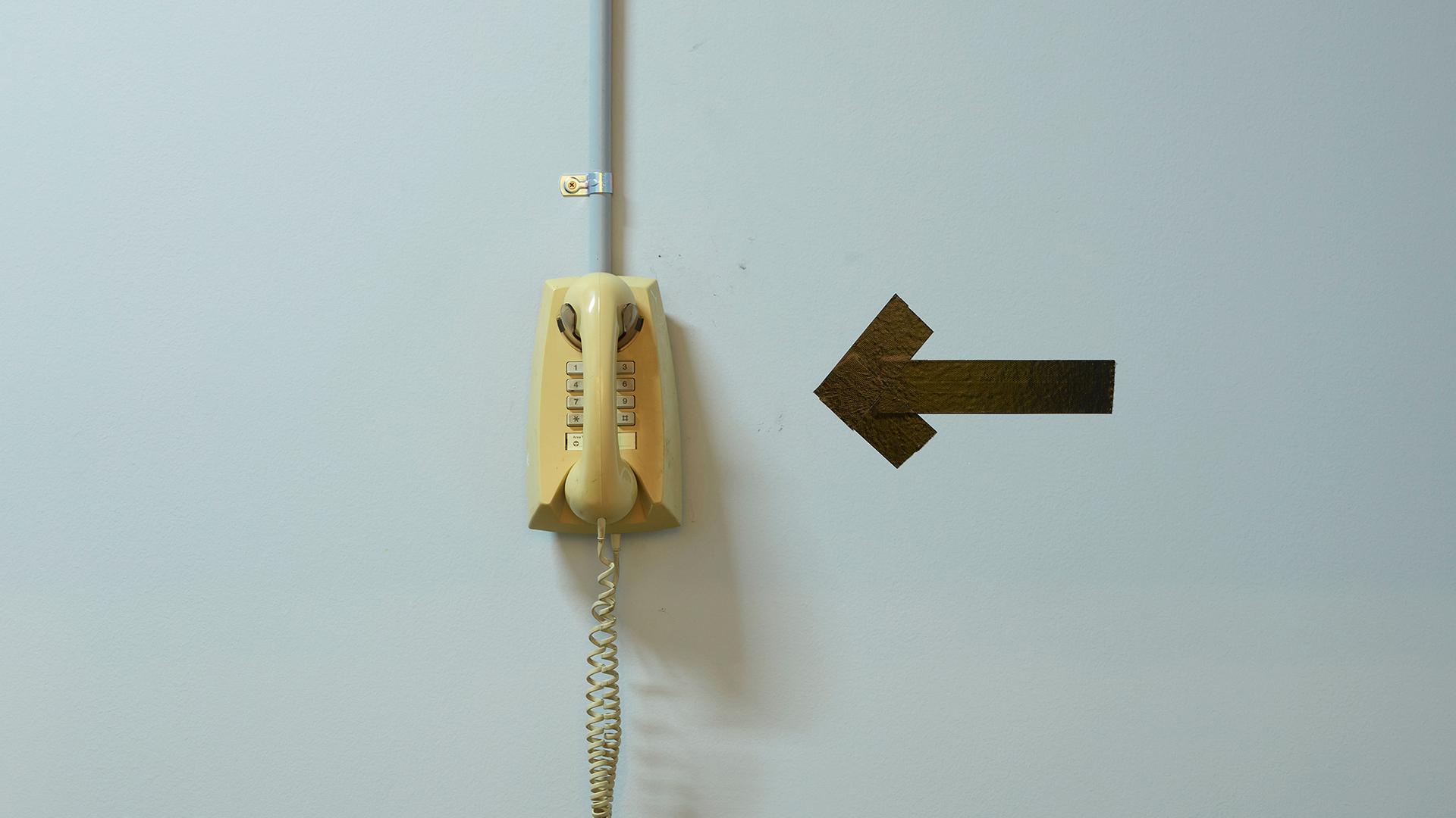 An old phone hangs on a wall