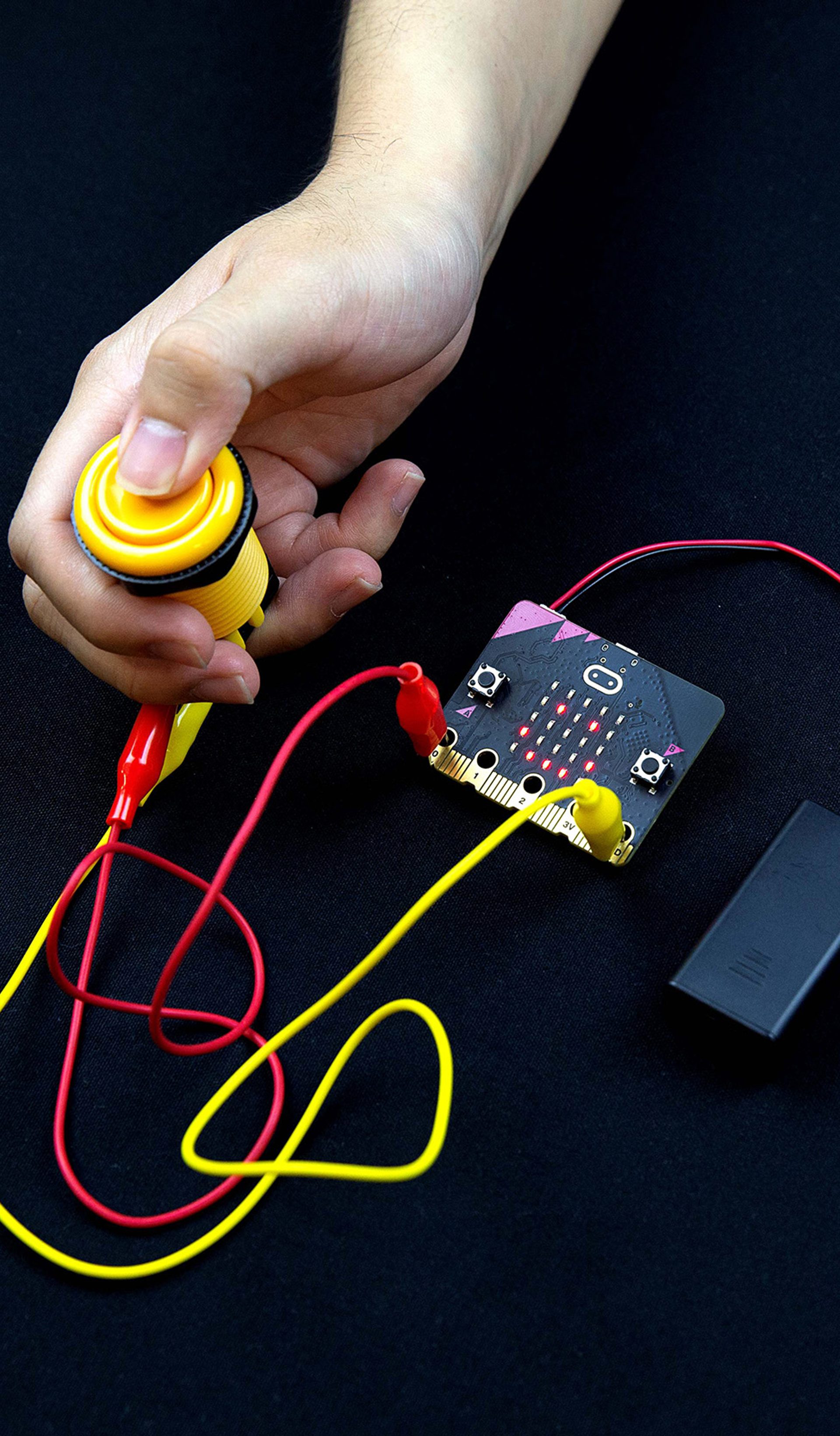 Micro:bit and button being pressed.