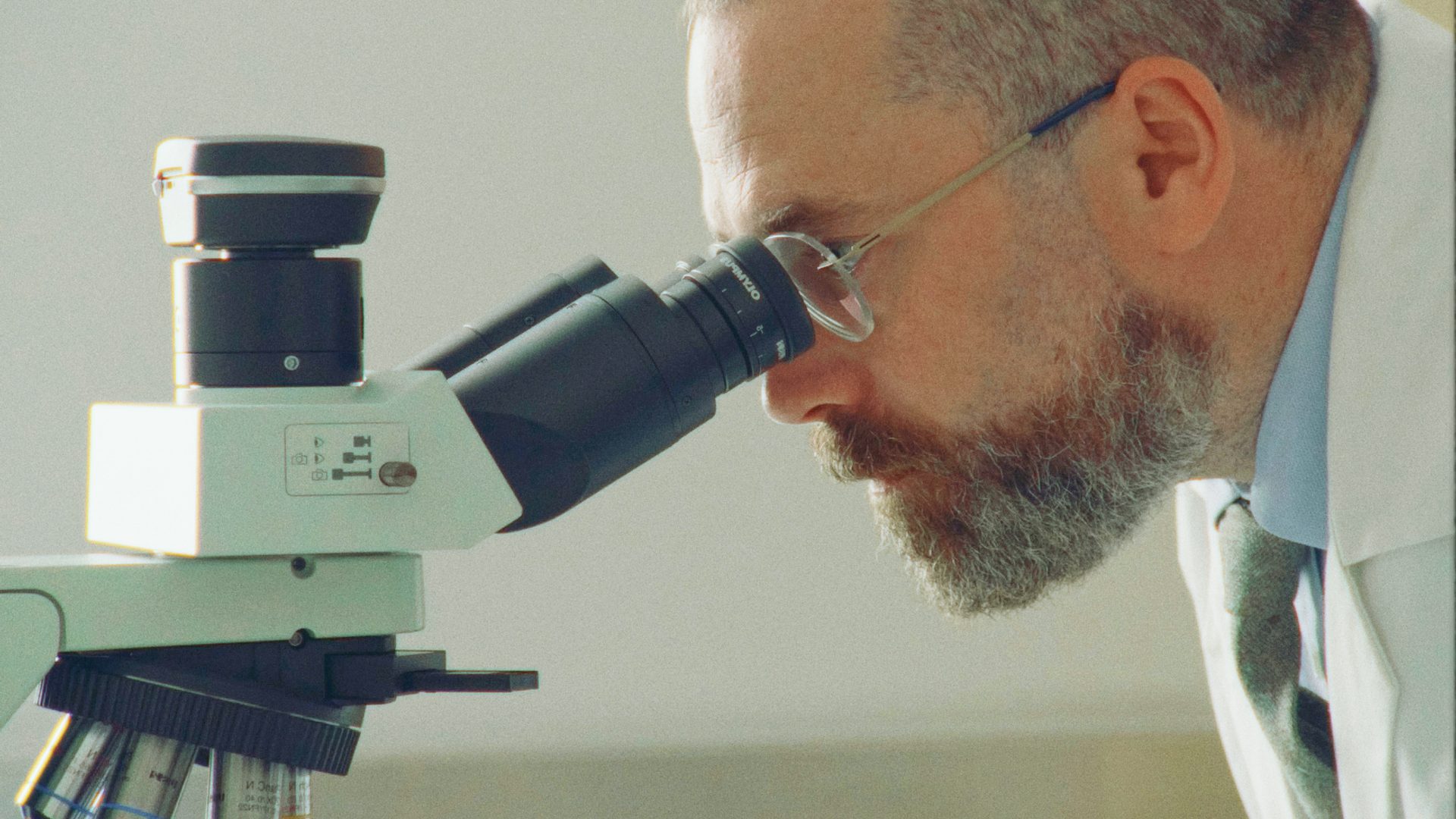 Conservator looking into microscope.