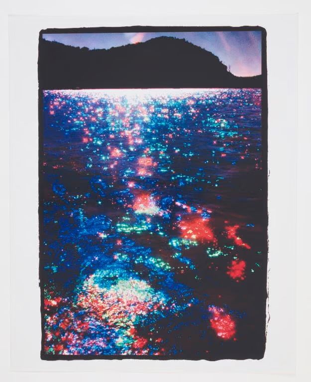 The sea glistening in red, green and blue.