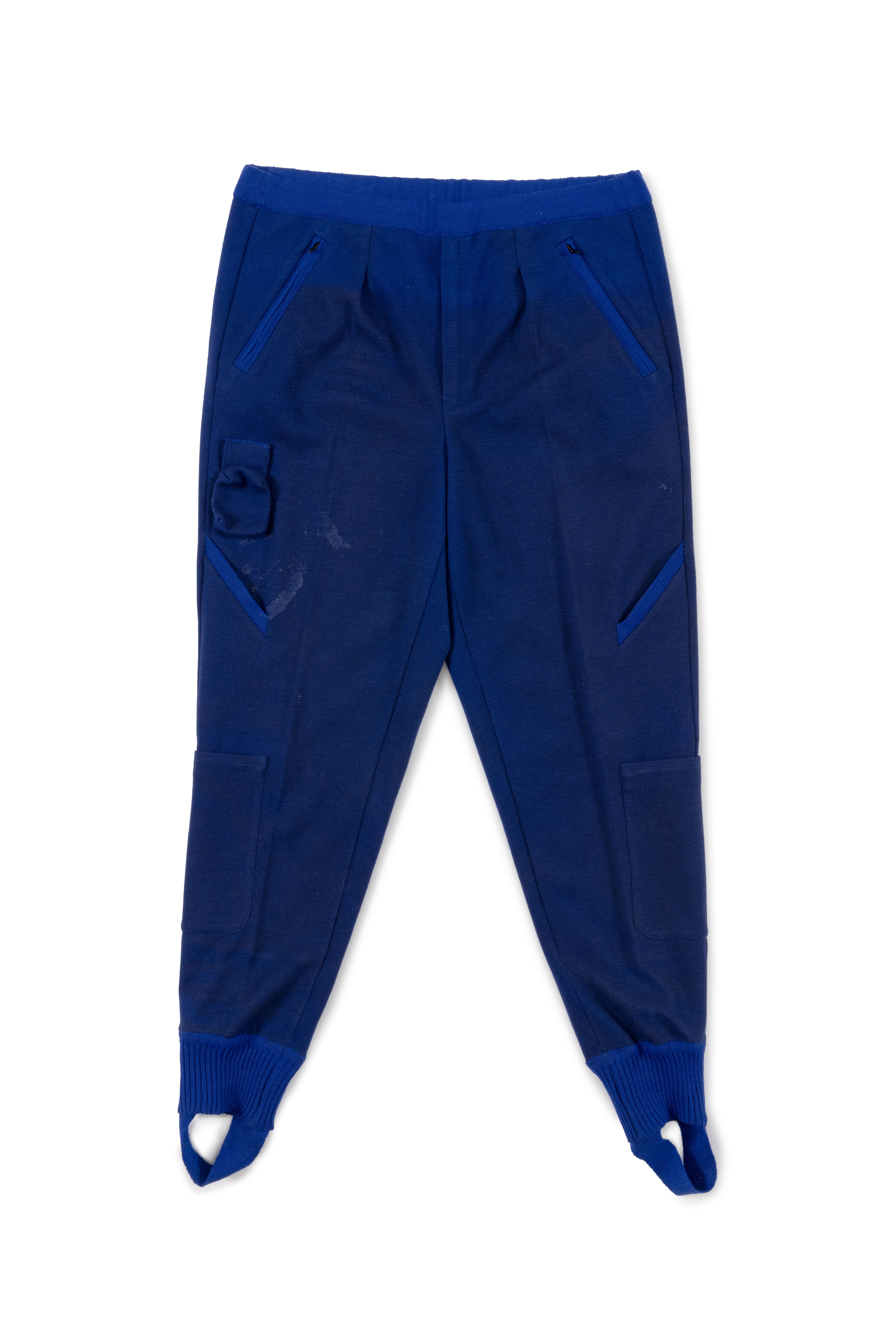 Photograph of the trousers a part of a five piece royal blue polyester wool blend flight suit with white trims, emblems and patches.