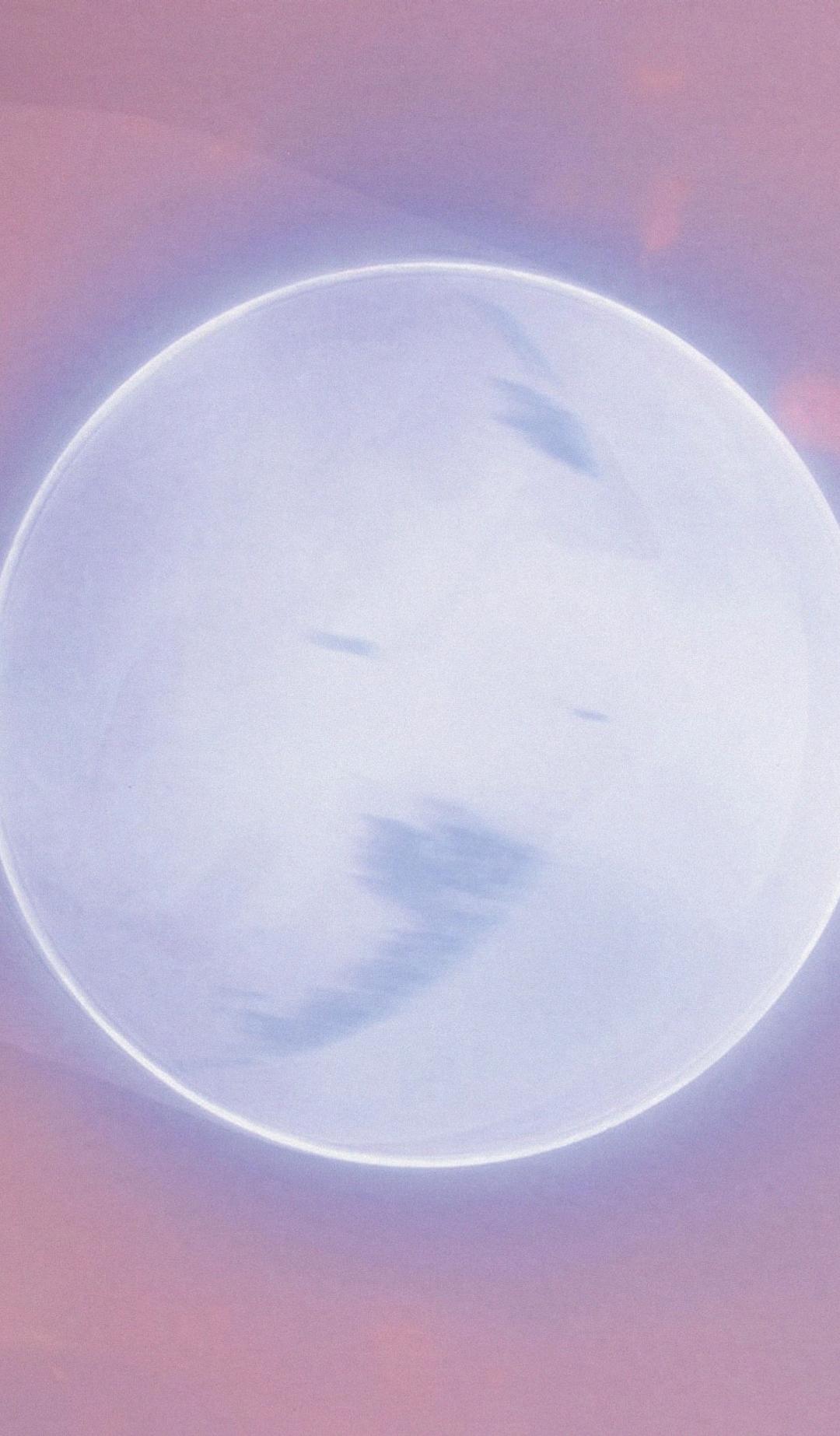 Grey planet lit with a silver ring, and surrounded in pink.
