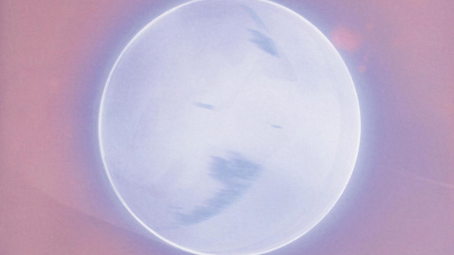 Grey planet lit with a silver ring, and surrounded in pink.