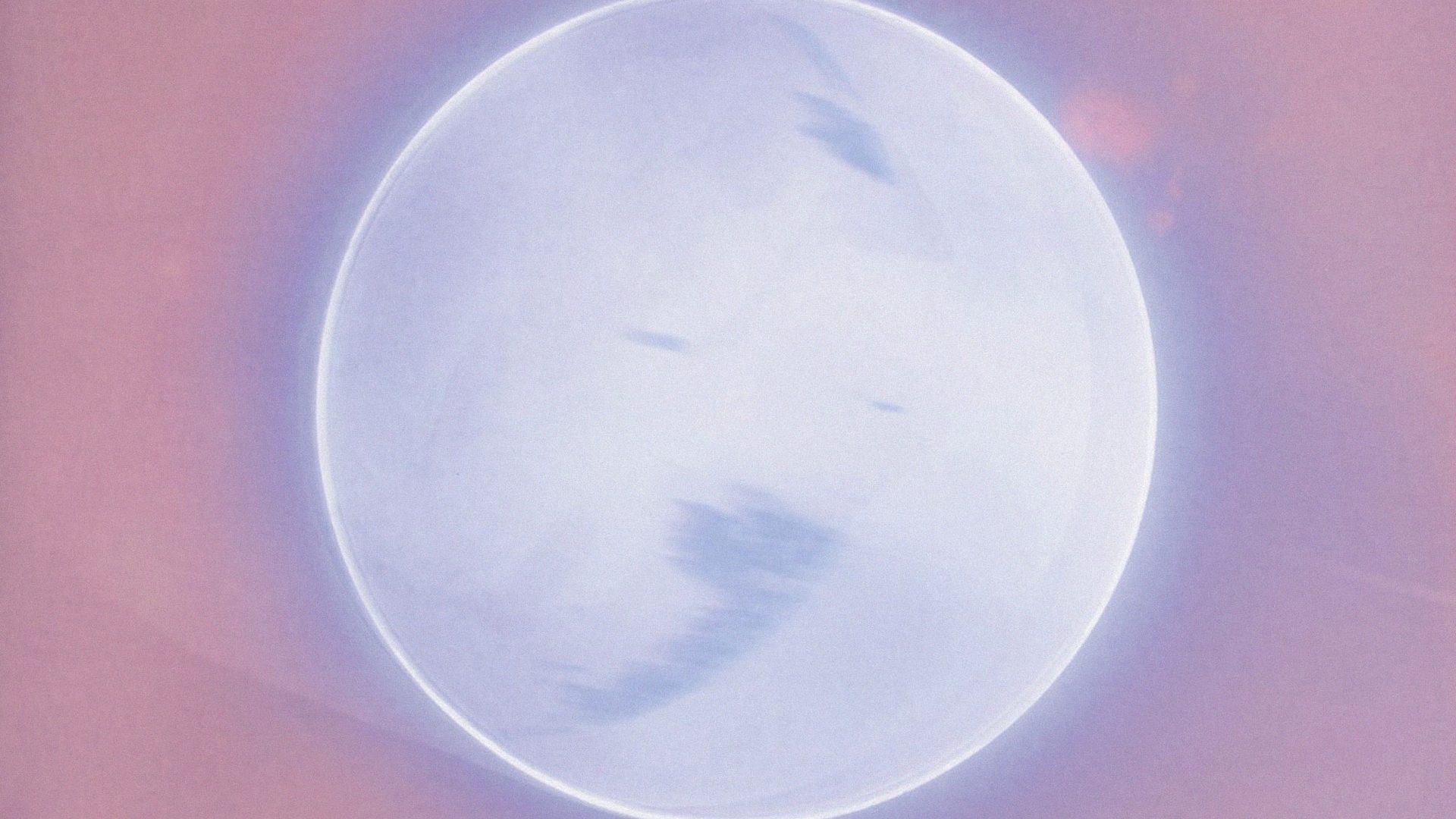 Grey planet lit with a silver ring, and surrounded in pink.