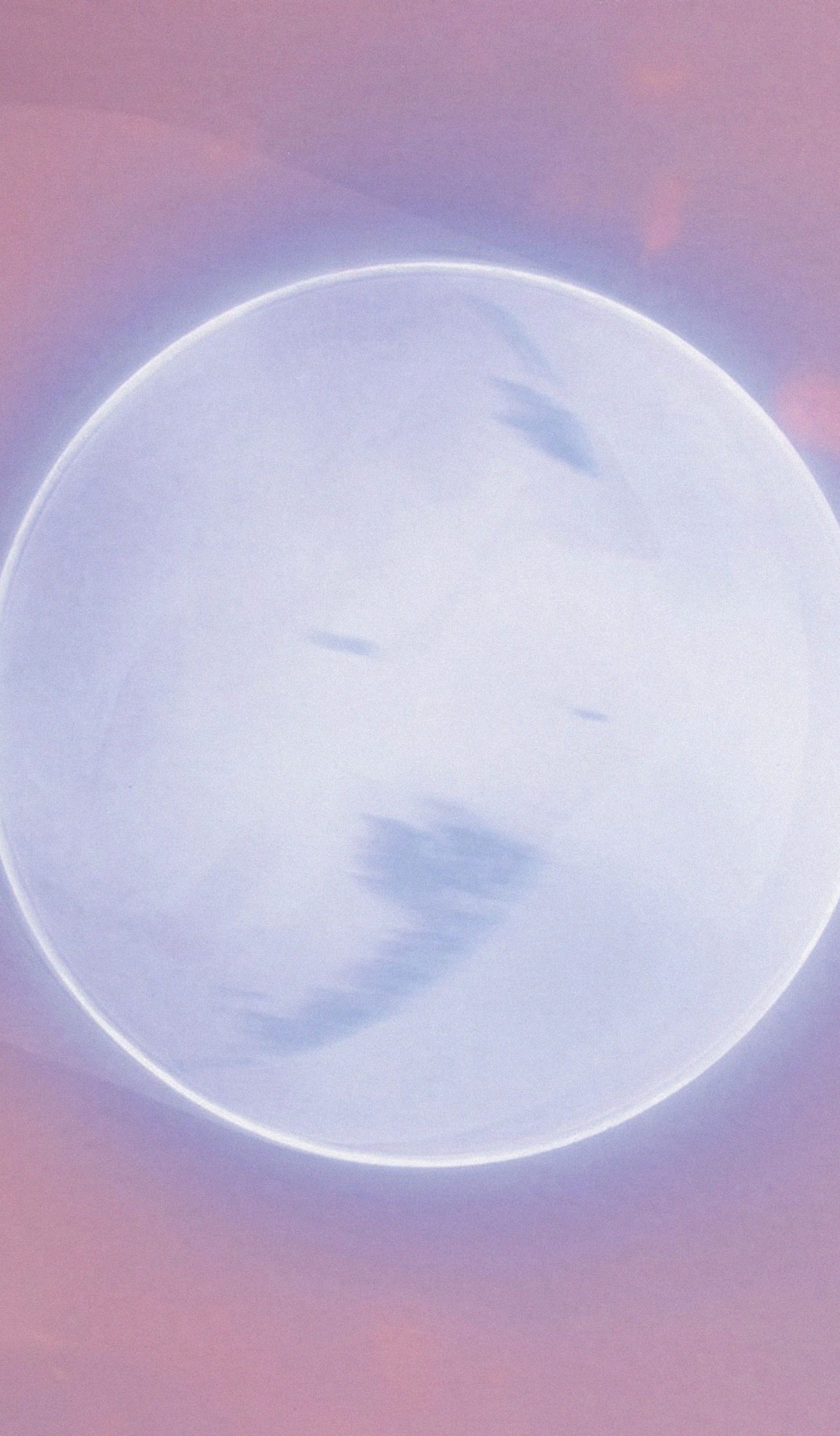 Grey planet lit with a silver ring, and surrounded in pink.