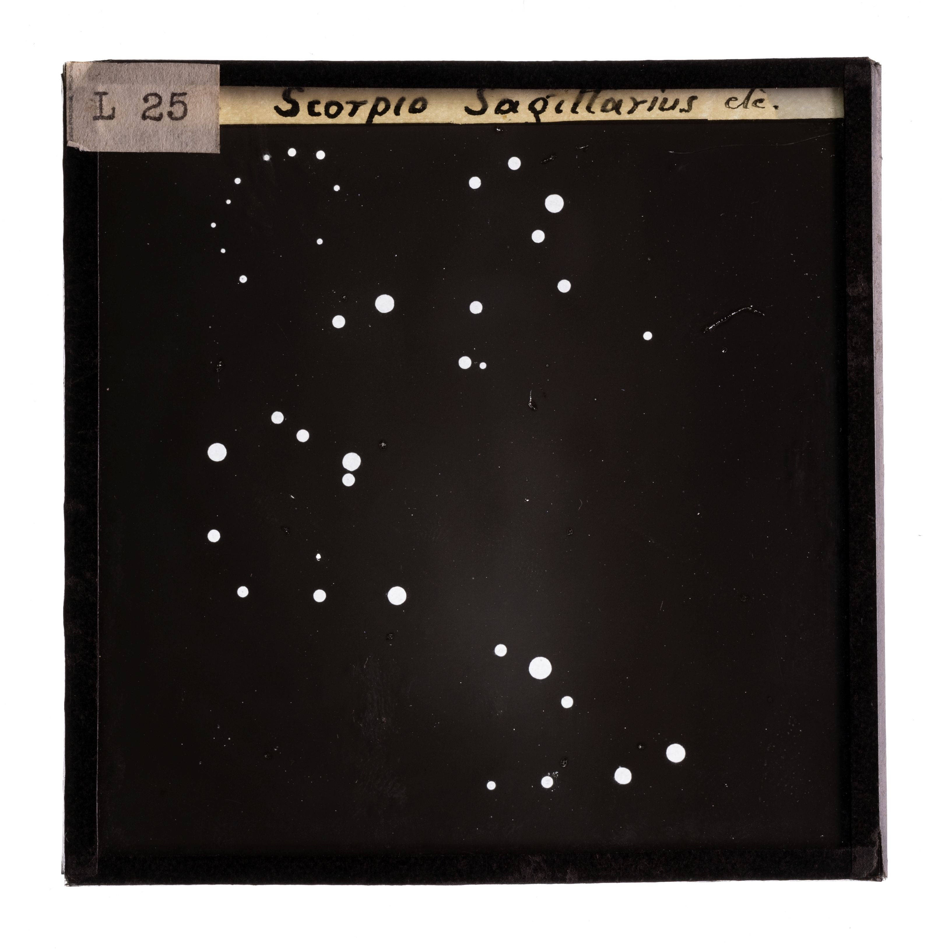 Glass plate slide of constellations Scorpio and Sagittarus, a black night sky with white dots to indicate the mapping of the constellations.