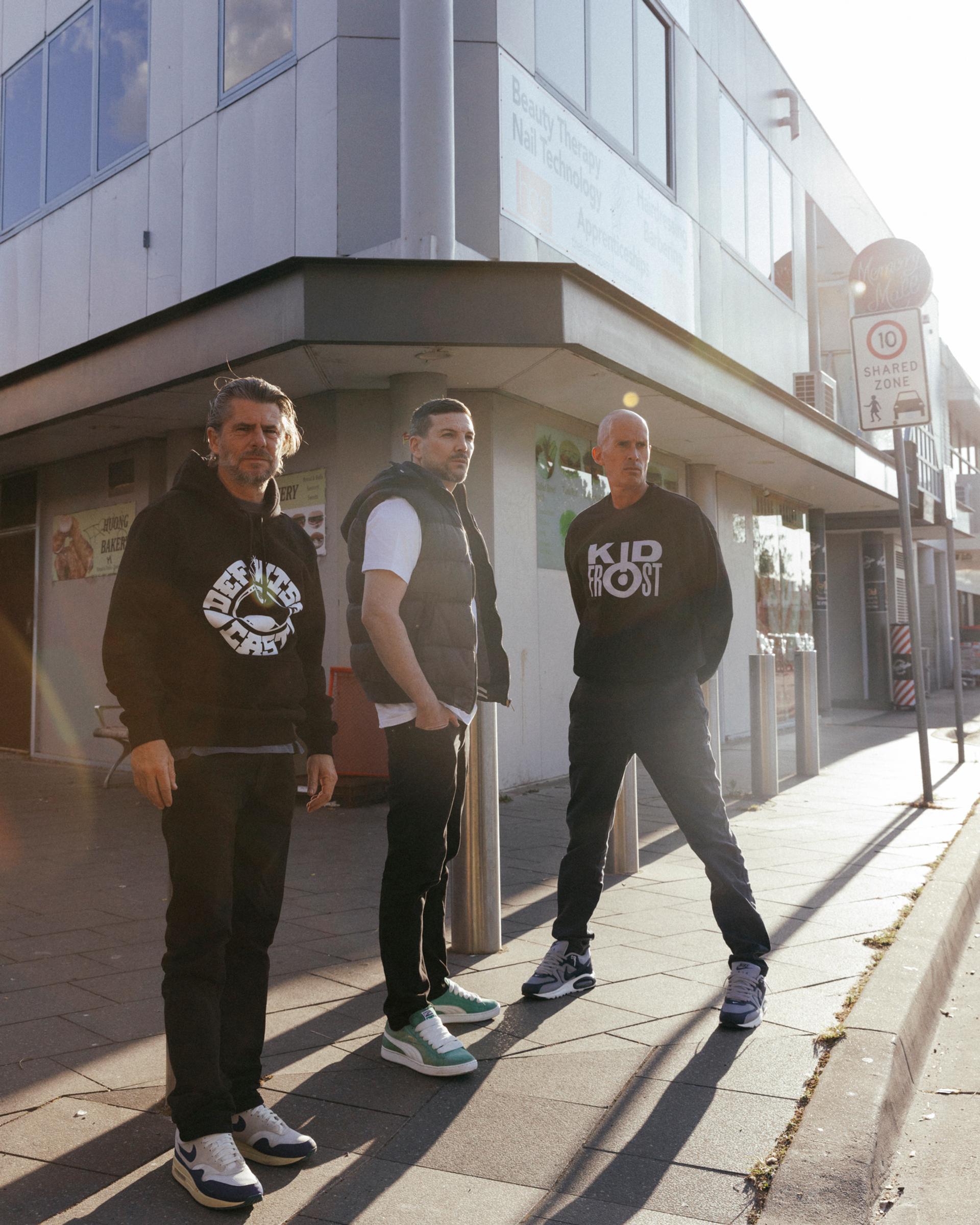 Three men standing on a street